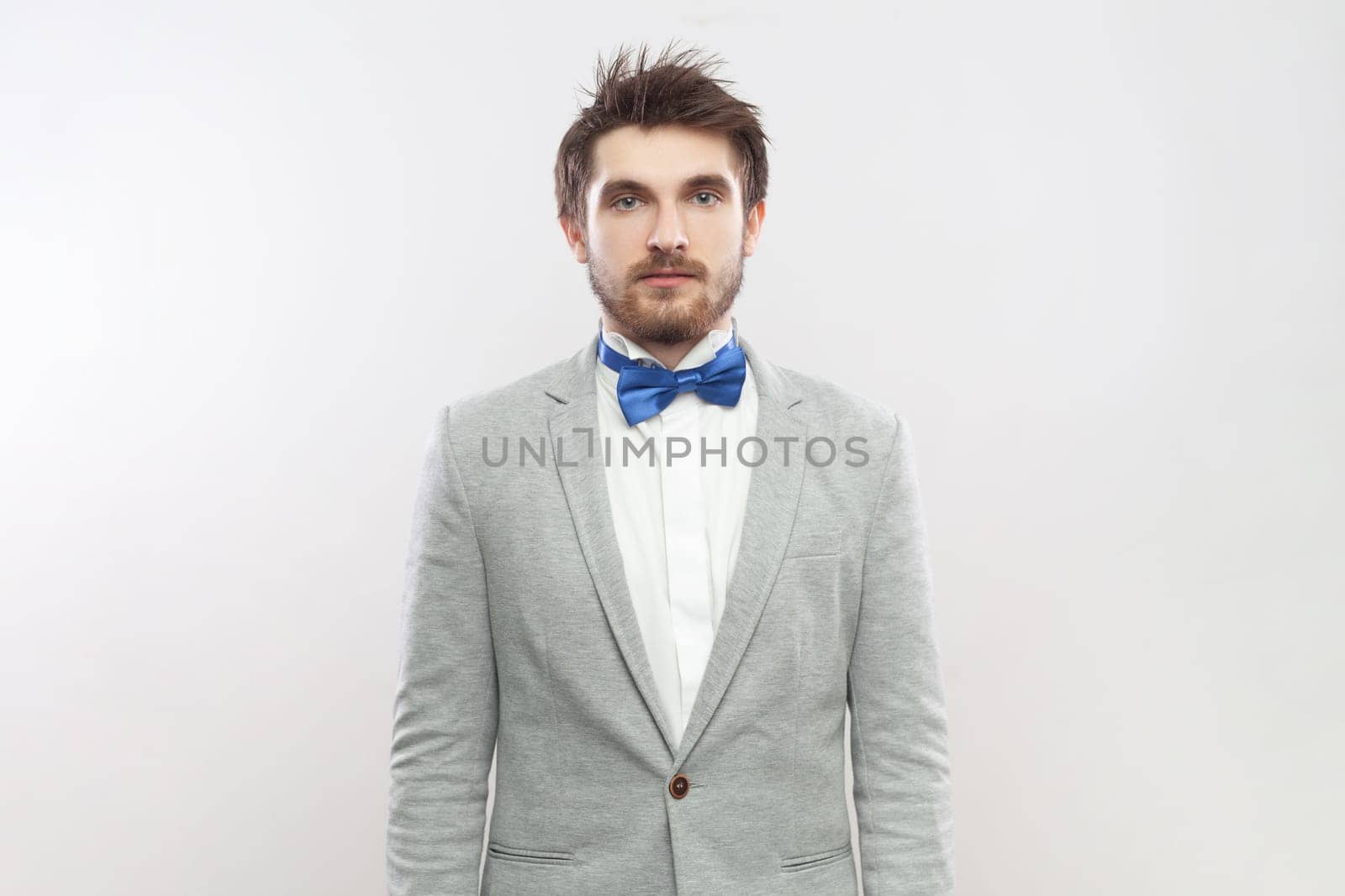 Serious attentive concentrated bearded man standing looking at camera with strict bossy expression. by Khosro1