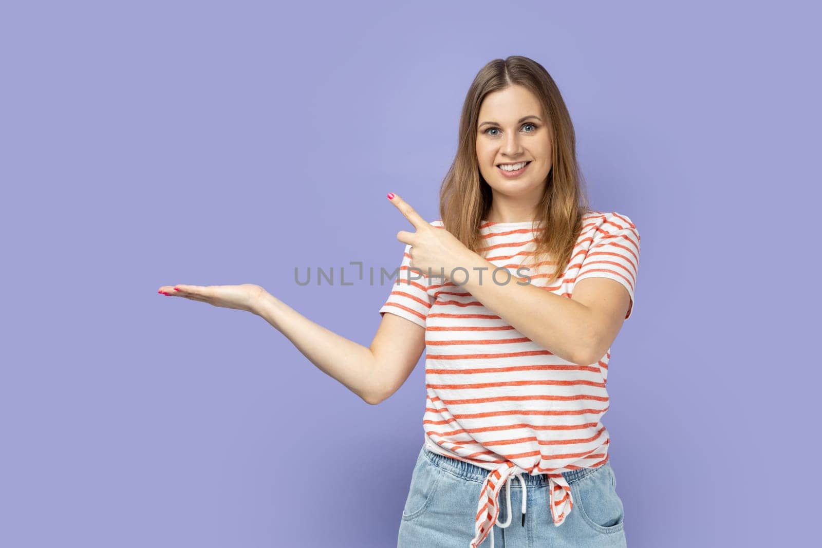 Woman presenting advertising area on her palm and pointing to copy space, holding empty place. by Khosro1