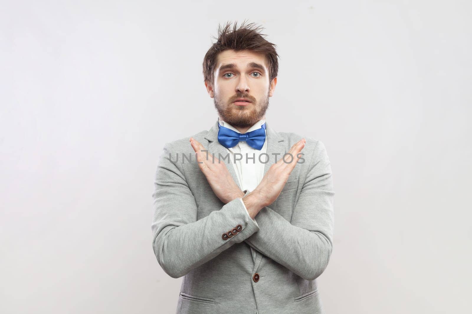 Upset attractive bearded man standing showing x sign, no way gesture, looking at camera. by Khosro1