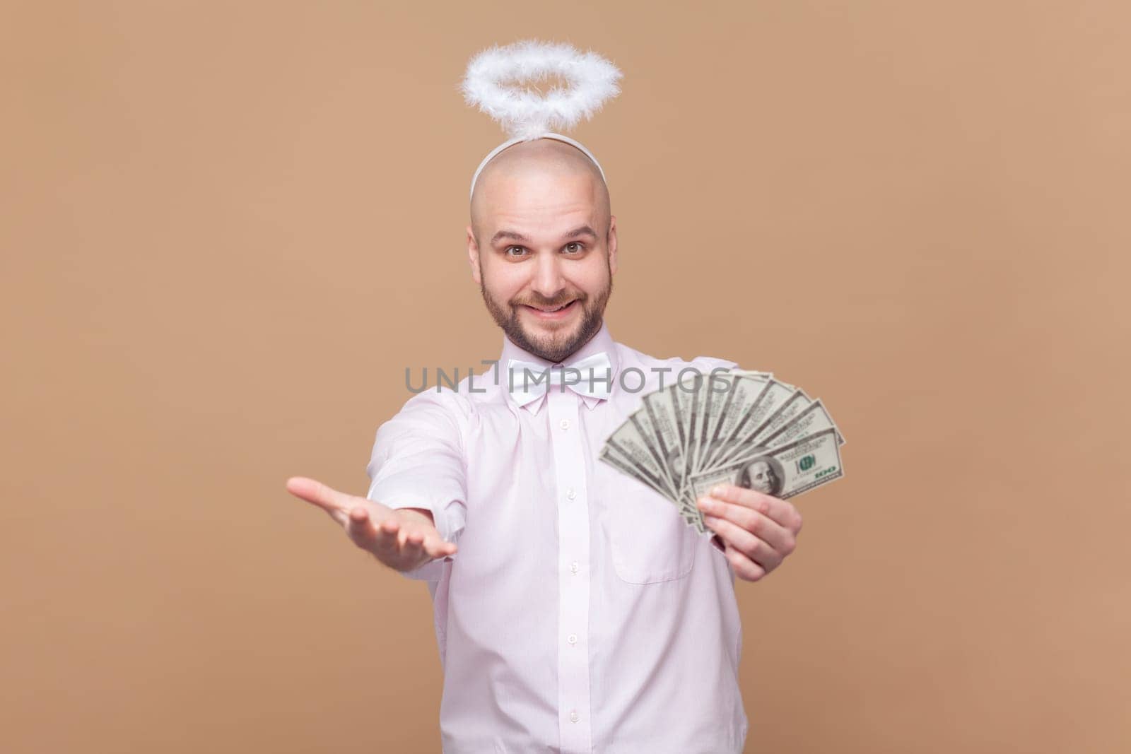 Satisfied rich bald bearded man with nimb over head, showing dollar banknotes, giving you salary. by Khosro1