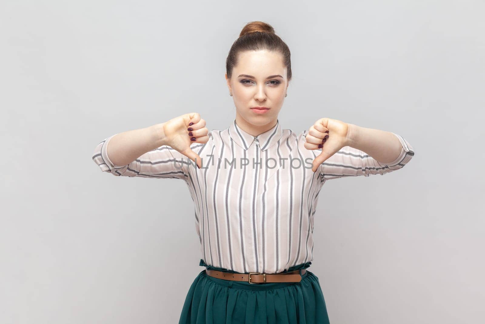 Dissatisfied displeased attractive woman standing showing dislike gesture, looks unhappy. by Khosro1