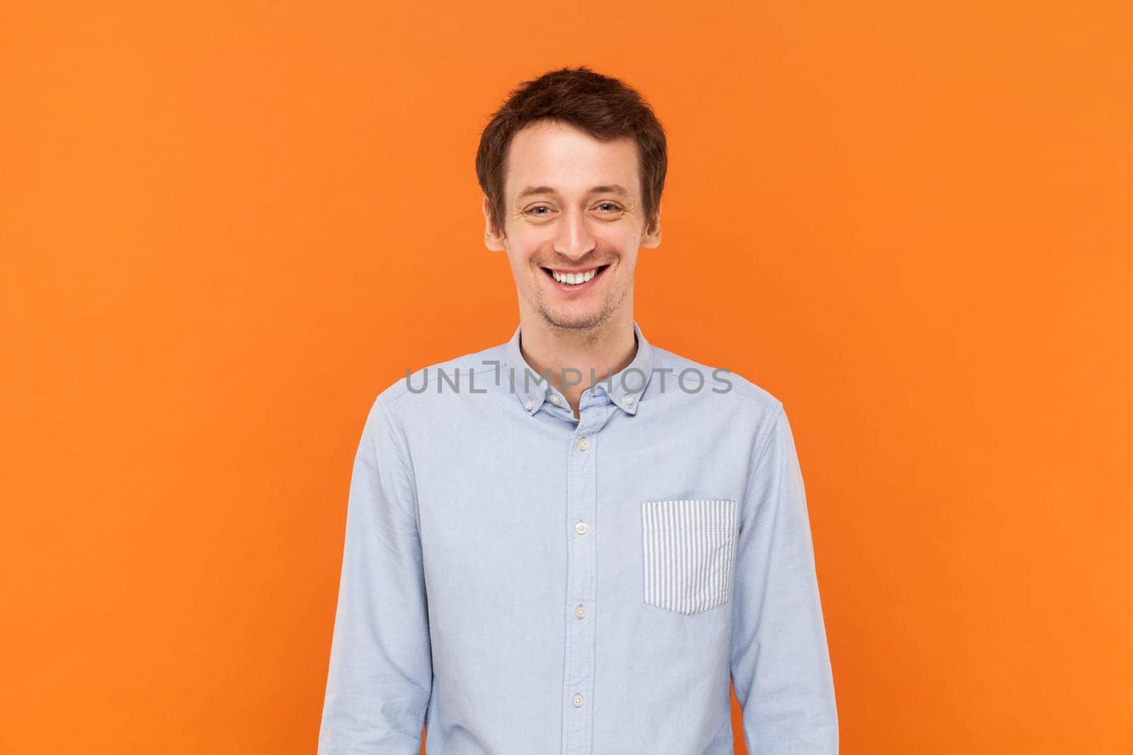 Overjoyed positive happy man standing looking at camera with toothy smile, expressing happiness. by Khosro1