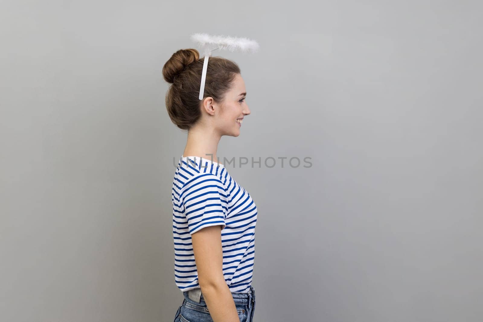 Side view of woman with nimbus over her head standing and looking ahead with positive expression. by Khosro1