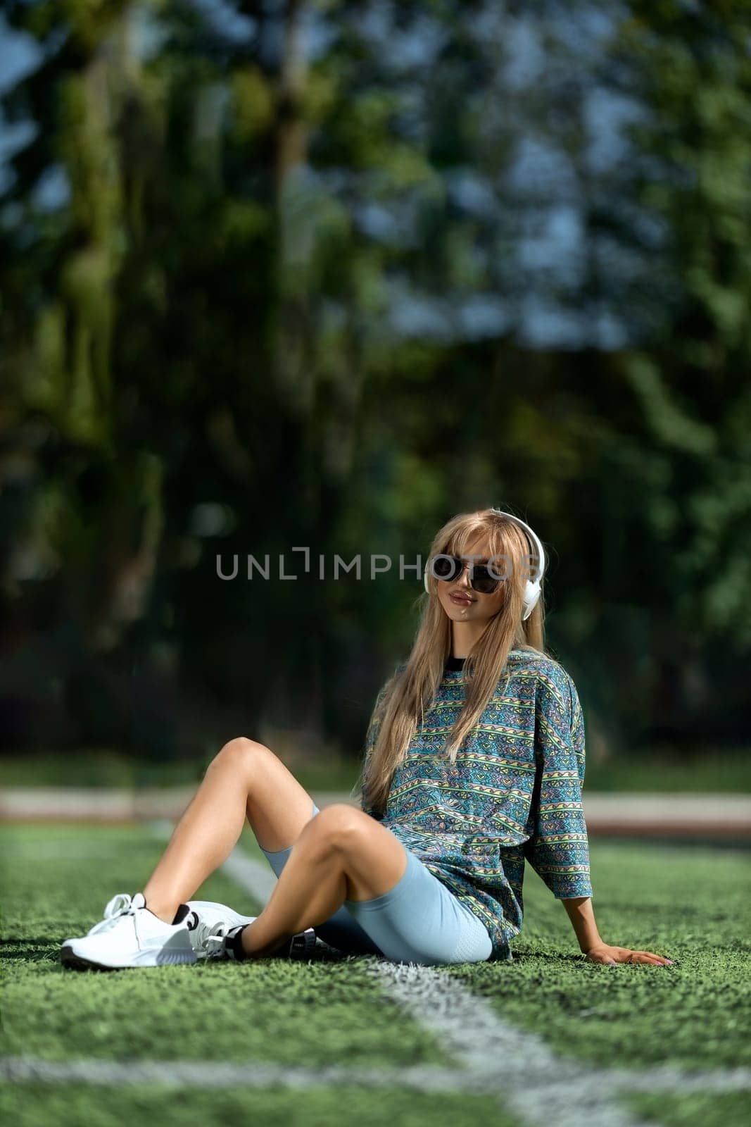 blonde athletic girl sitting on the football field