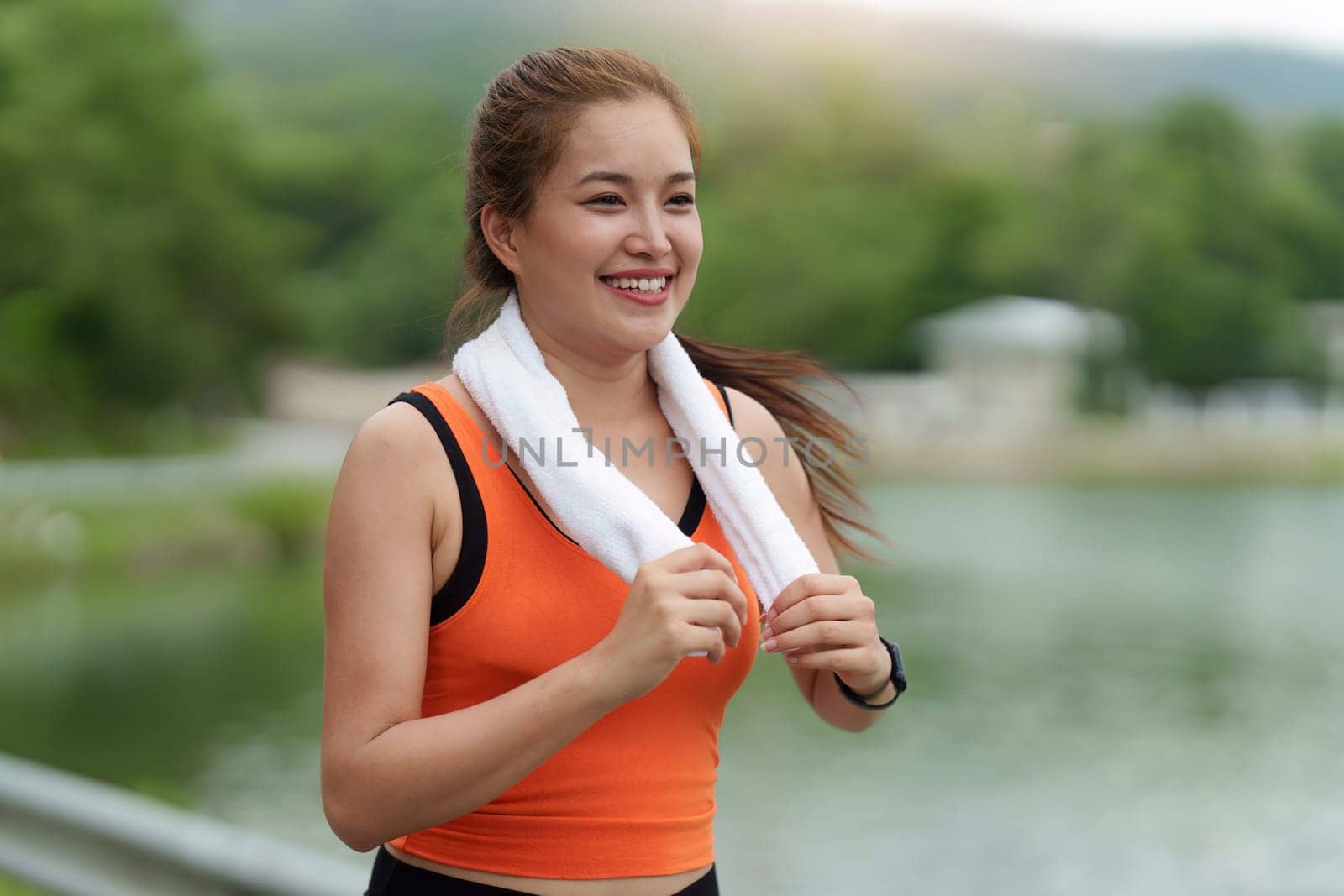 Healthy Asian woman is jogging outdoor. Fitness girl running. Female exercising at outdoor park.