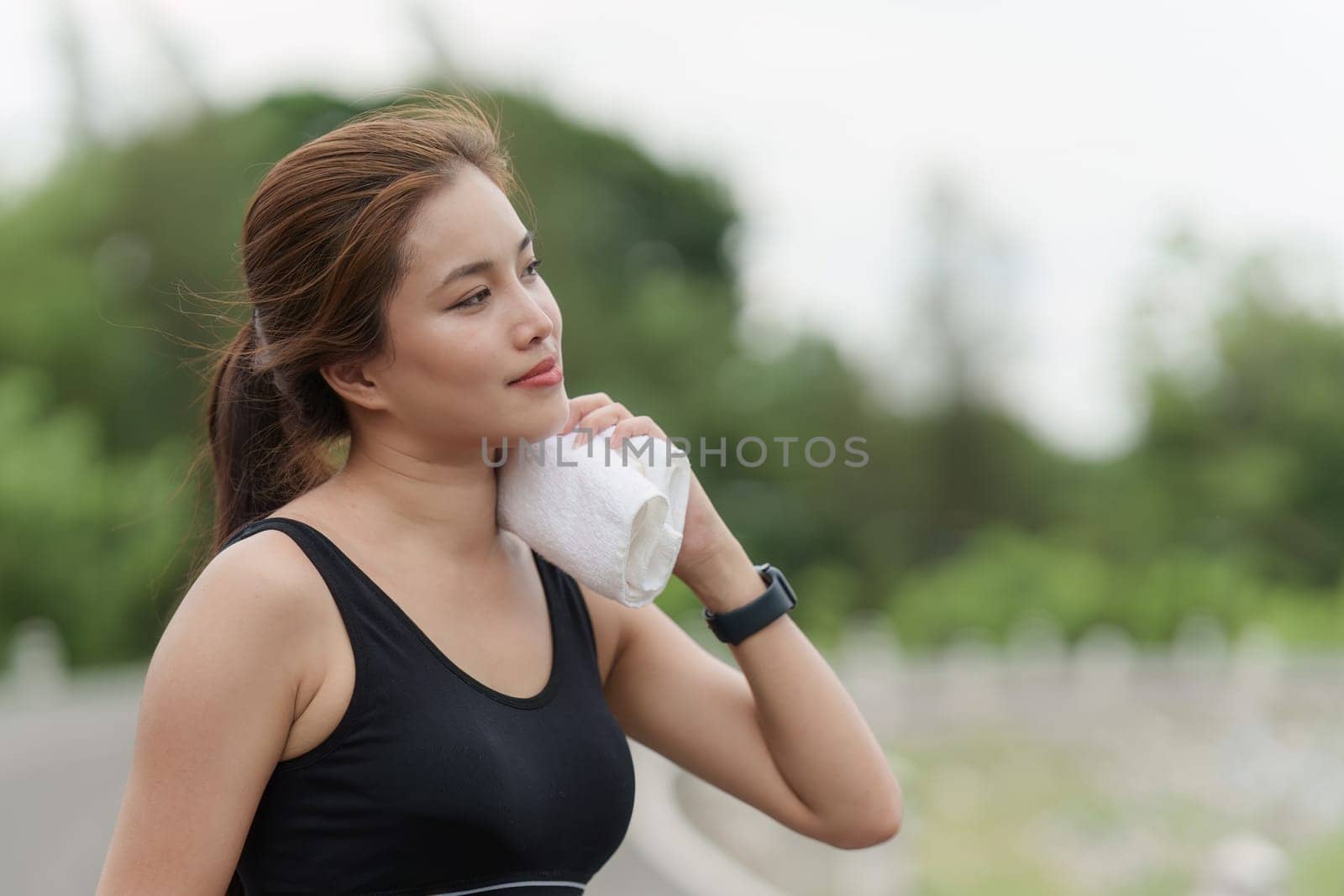 Healthy Asian woman is jogging outdoor. Fitness girl running. Female exercising at outdoor park by itchaznong