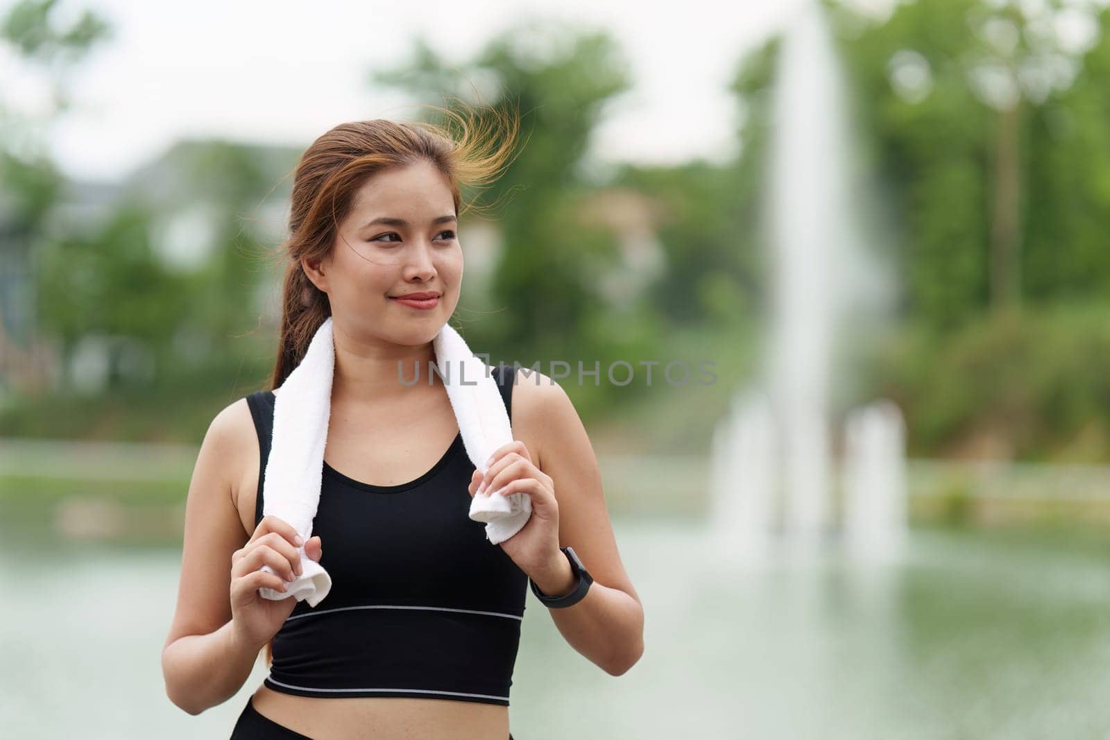 Healthy Asian woman is jogging outdoor. Fitness girl running. Female exercising at outdoor park.