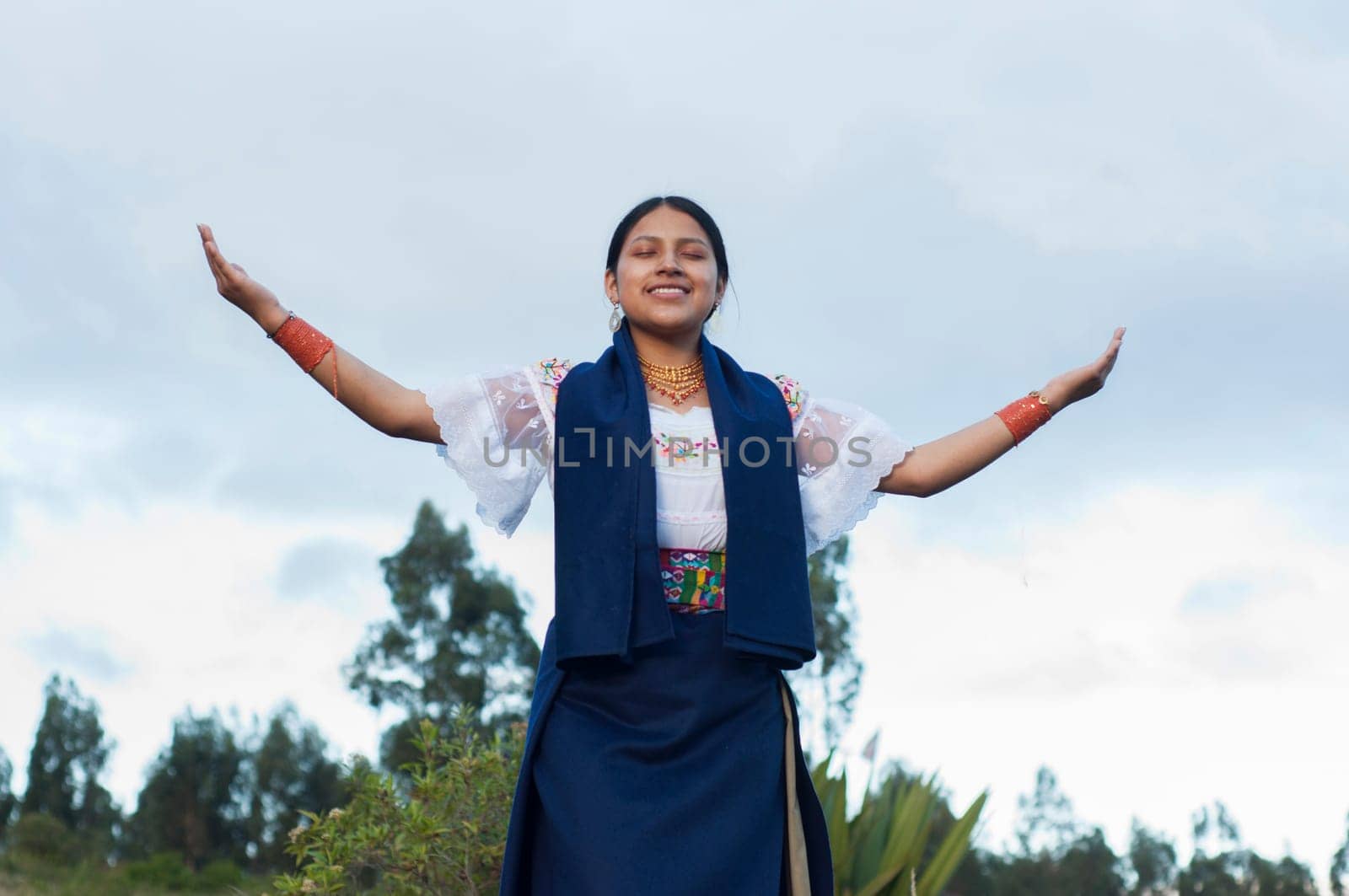 pretty indigenous girl raising her arms in crus in a traditional ceremony in the amazon of ecuador. High quality photo
