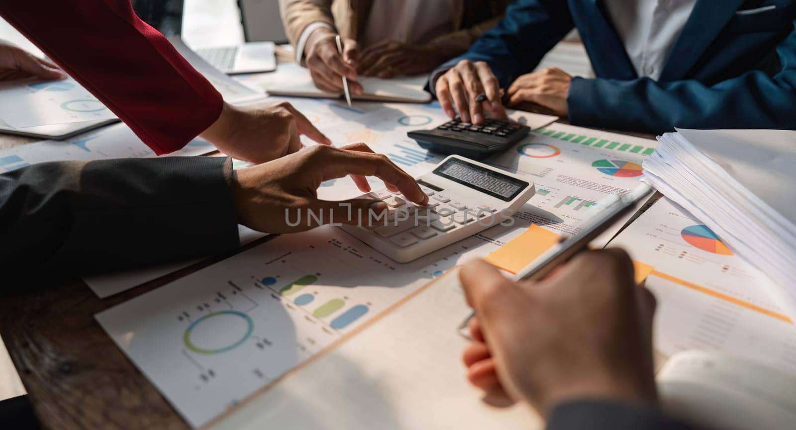 Business team analyzes financial business finance reports on laptop and graph documents during corporate meeting discussions showing successful teamwork, business meeting ideas.