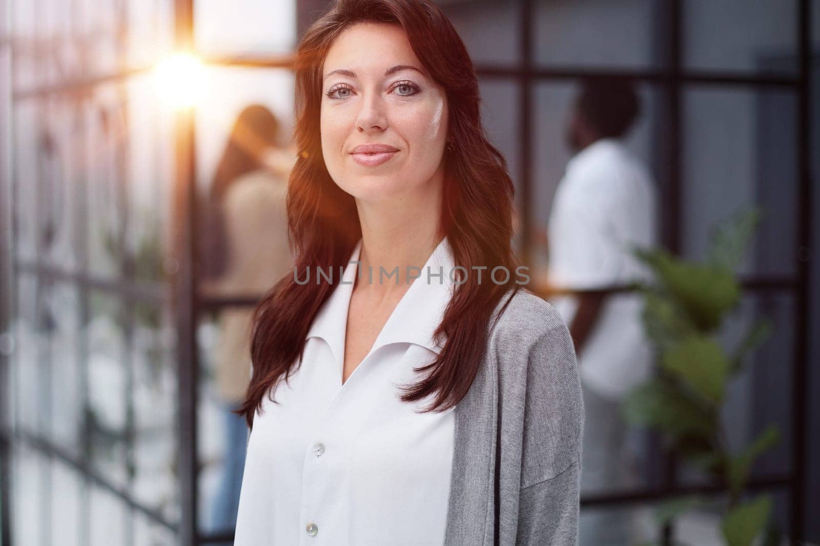 Portrait of a serious lady posing against the backdrop of a modern office.