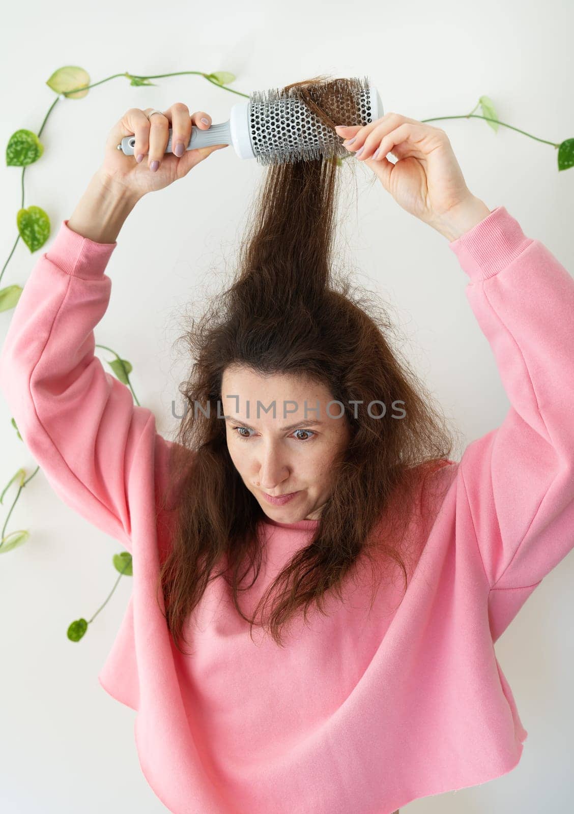 The girl dries her hair on a brush. Hair care. The concept of home care, drying healthy hair with a hair dryer and brush. by sfinks