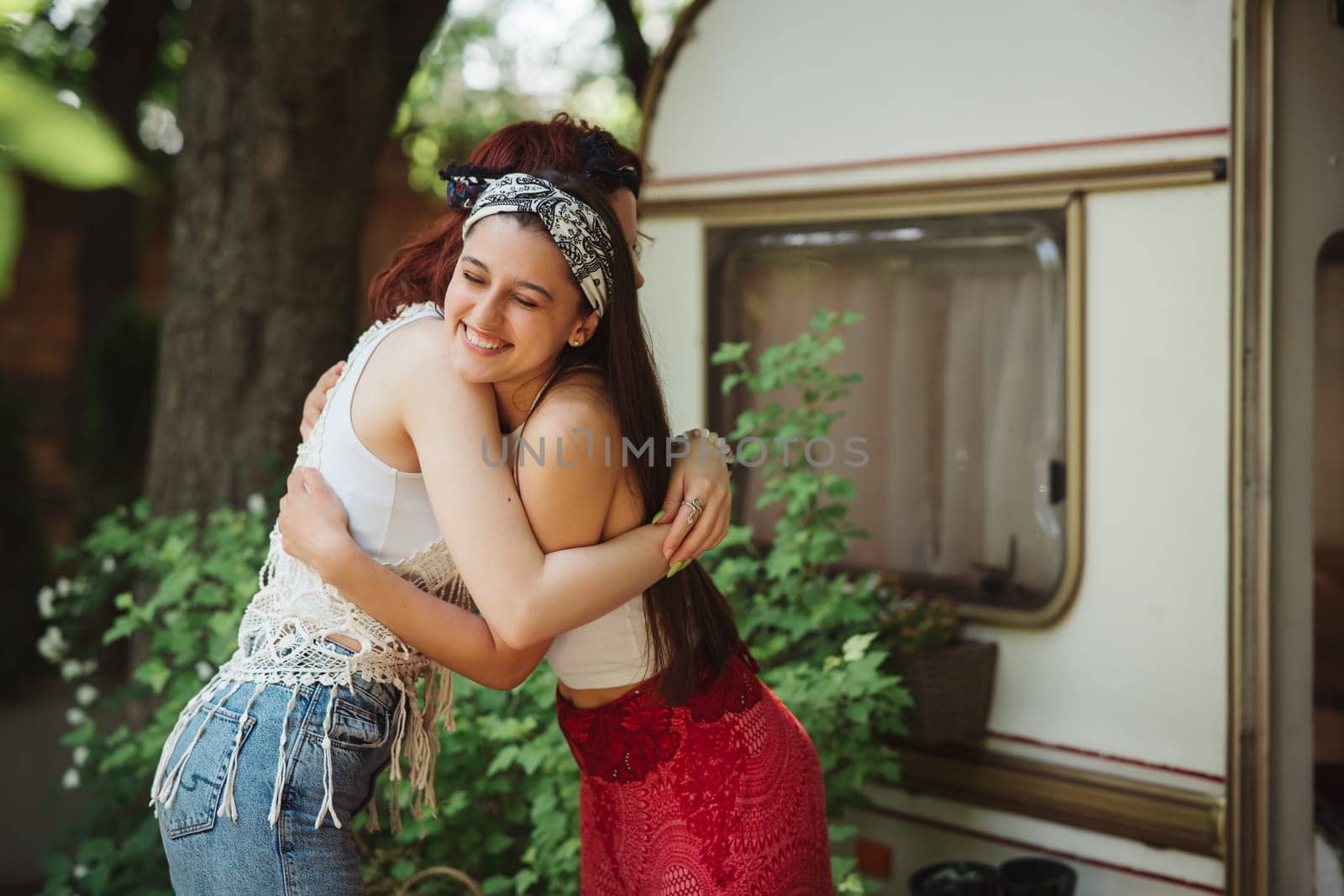 Happy hippie friends are having a good time together in camper trailer. Holiday, vacation, trip concept. High quality photo