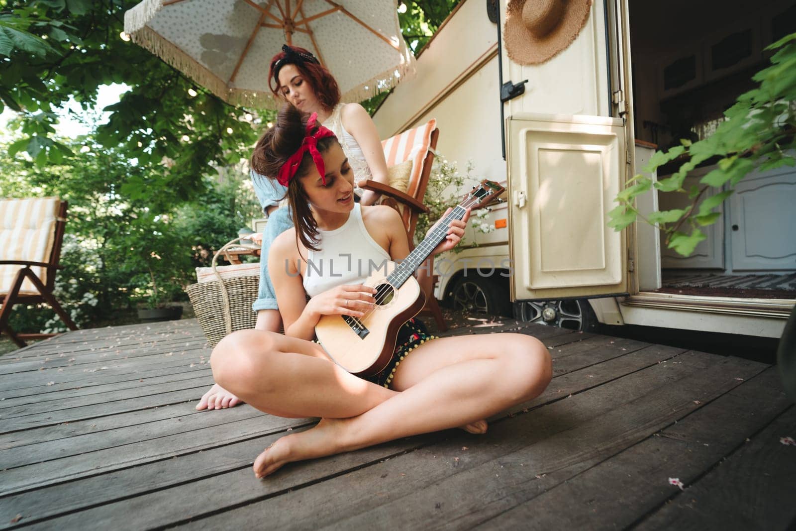 Happy hippie friends are having a good time together in camper trailer. Holiday, vacation, trip concept. High quality photo