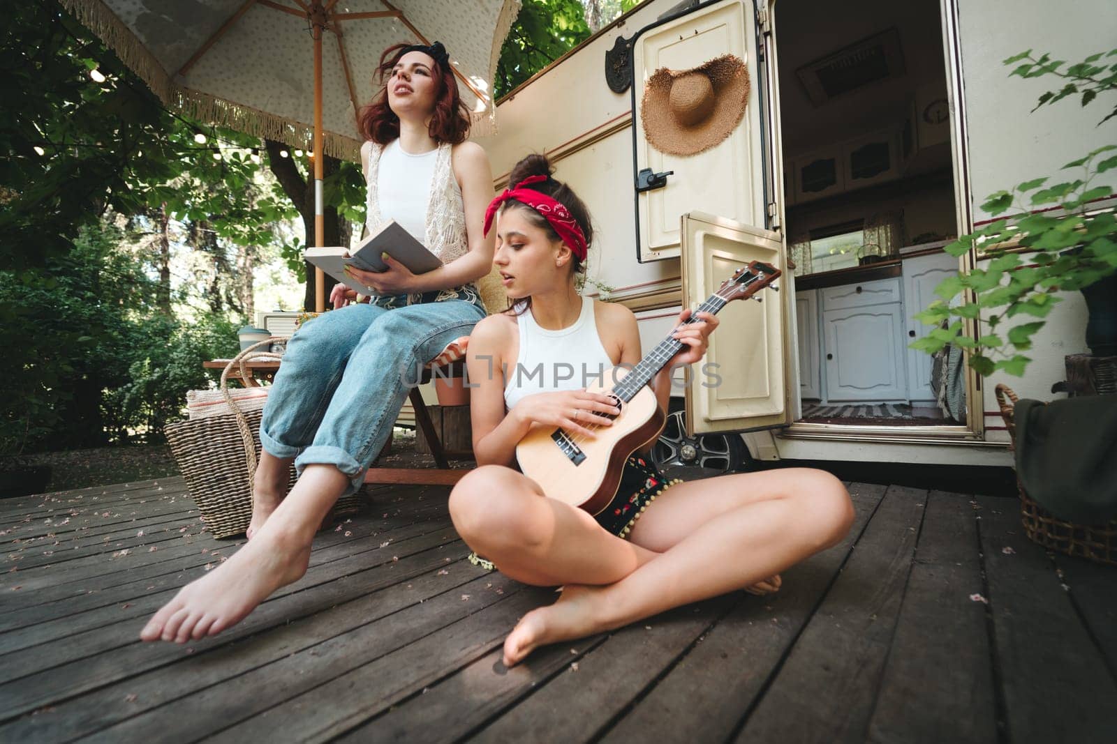 Happy hippie friends are having a good time together in camper trailer. Holiday, vacation, trip concept. High quality photo