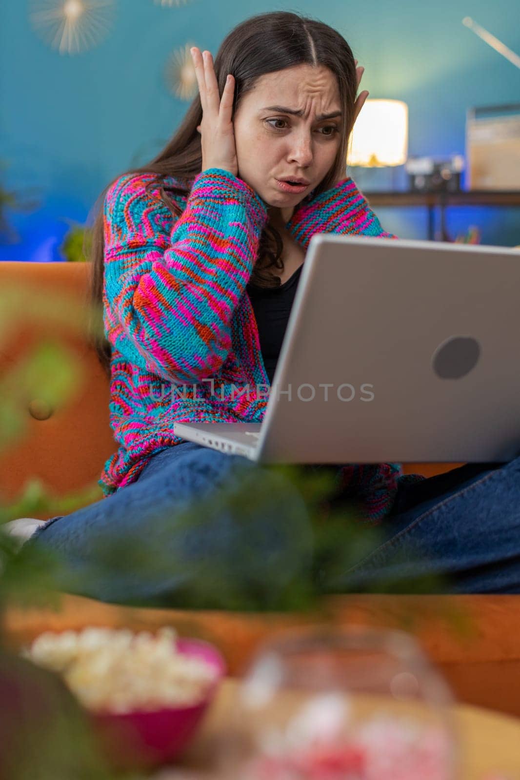 Displeased Caucasian woman use laptop notebook typing browsing working, loses becoming surprised sudden lottery results bad news fortune loss fail computer virus. Young girl at home in room on couch