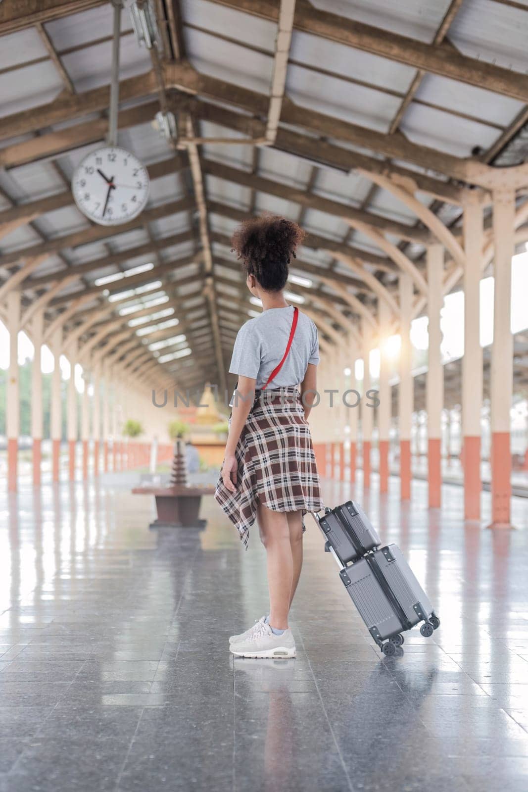 Young female traveler walking standing with a suitcase at train station. woman traveler tourist walking standing smiling with luggage at train station..