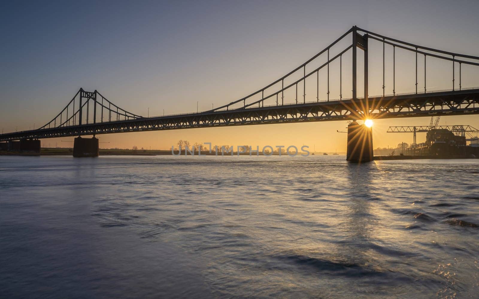 Old bridge crossing the Rhine river during sunset, Krefeld, North Rhine Westphalia, Germany