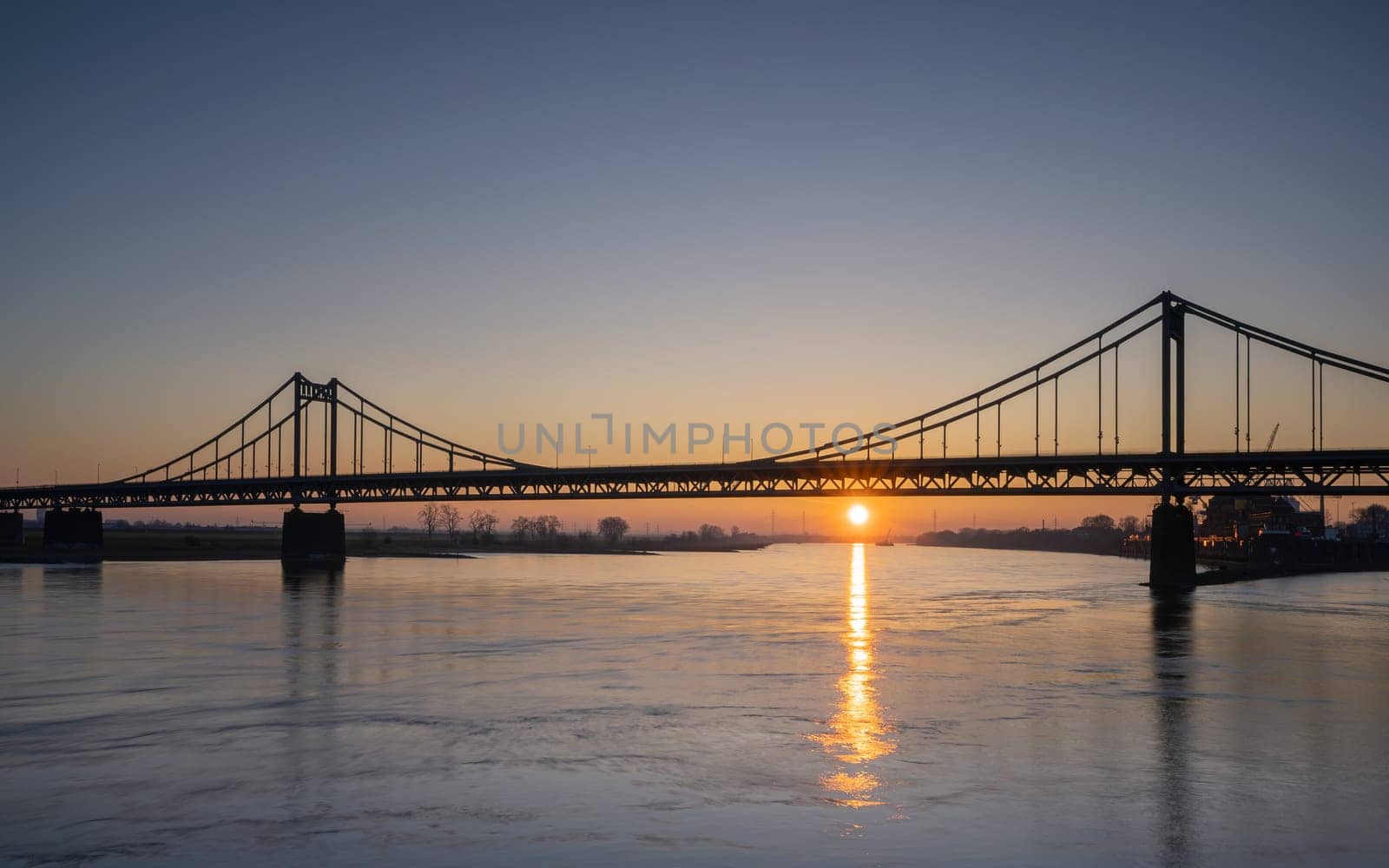 Old bridge crossing the Rhine river during sunset, Krefeld, North Rhine Westphalia, Germany