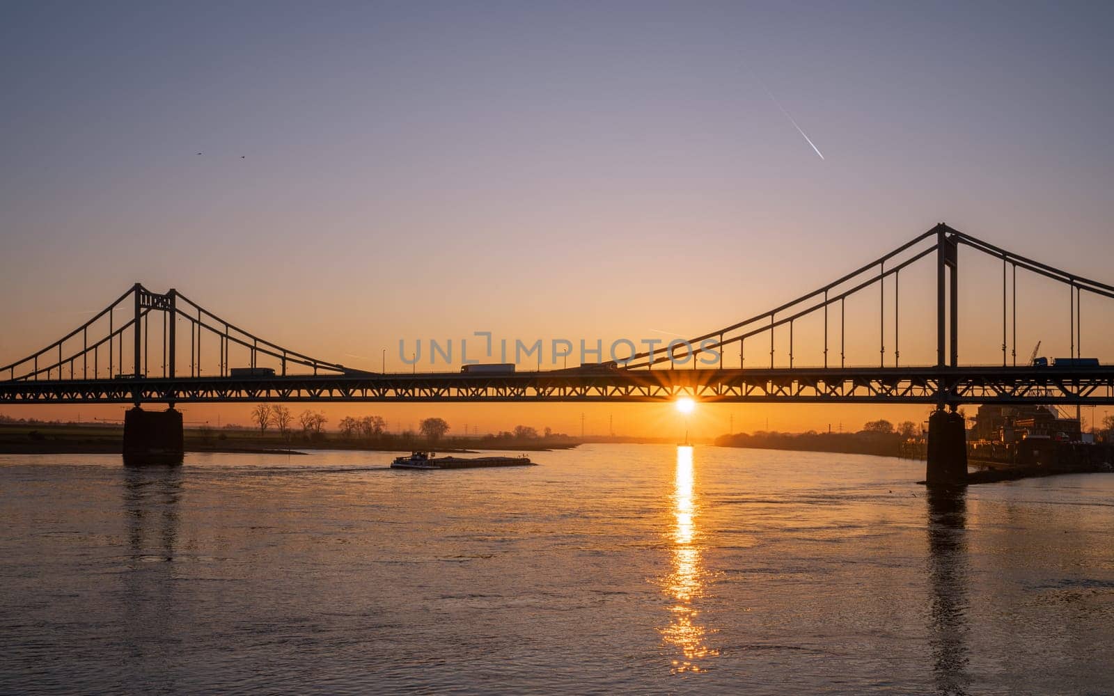 Old bridge crossing the Rhine river during sunset, Krefeld, North Rhine Westphalia, Germany