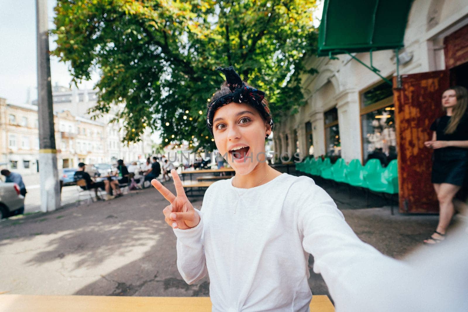 Close up portrait of a girl showing v-sign wear white t-shirt outdoor