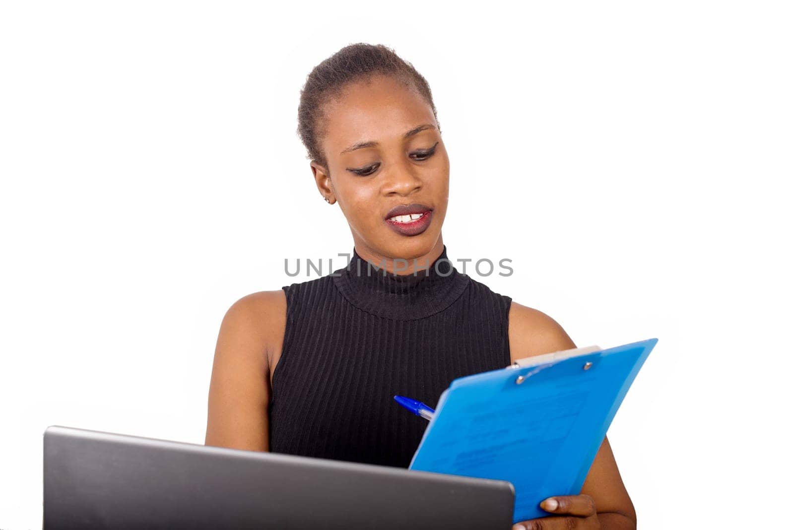 Young confident secretary or office manager sitting in front of his office and writing his business plan in front of his laptop