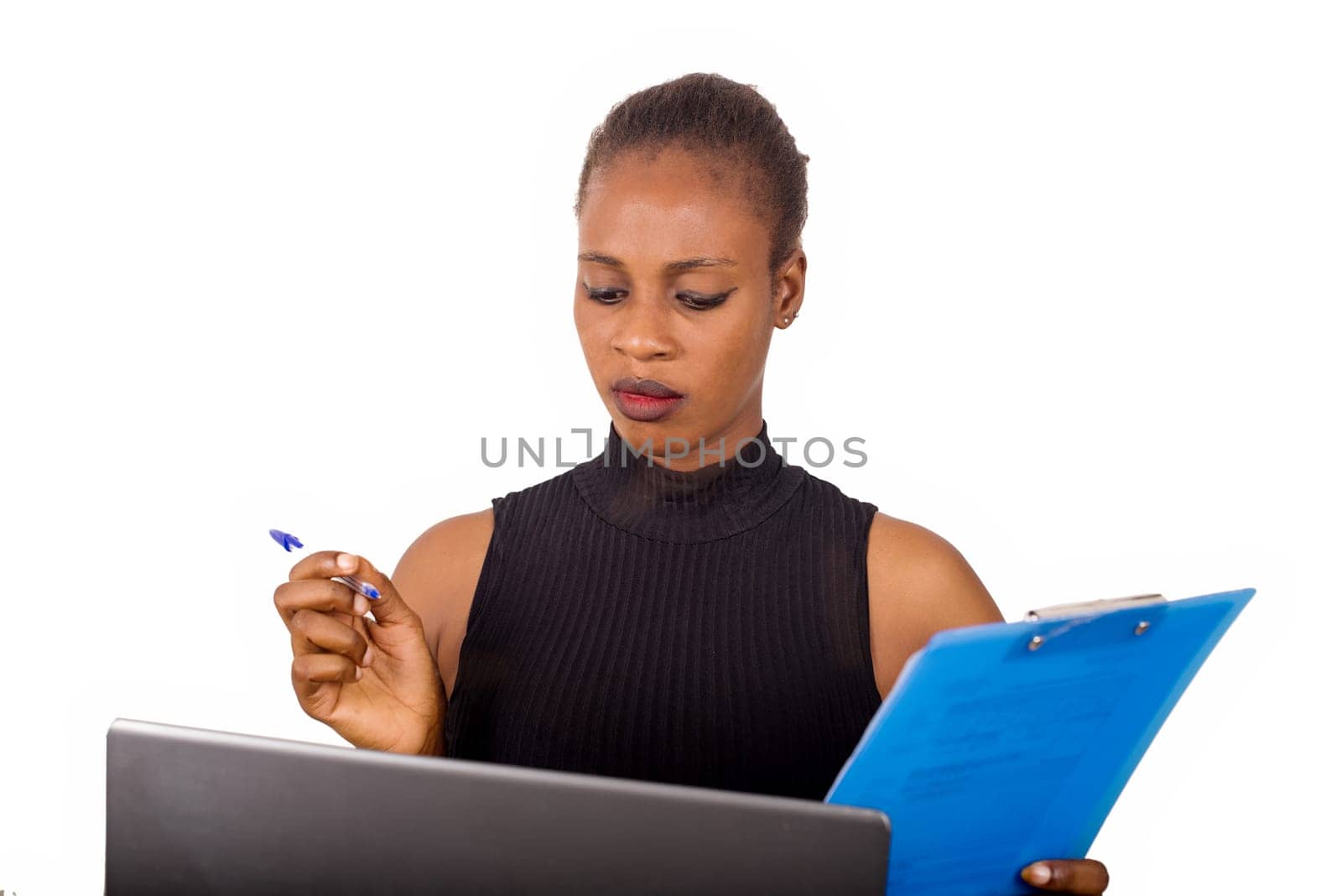 Young confident secretary or office manager sitting in front of his office and writing his business plan in front of his laptop