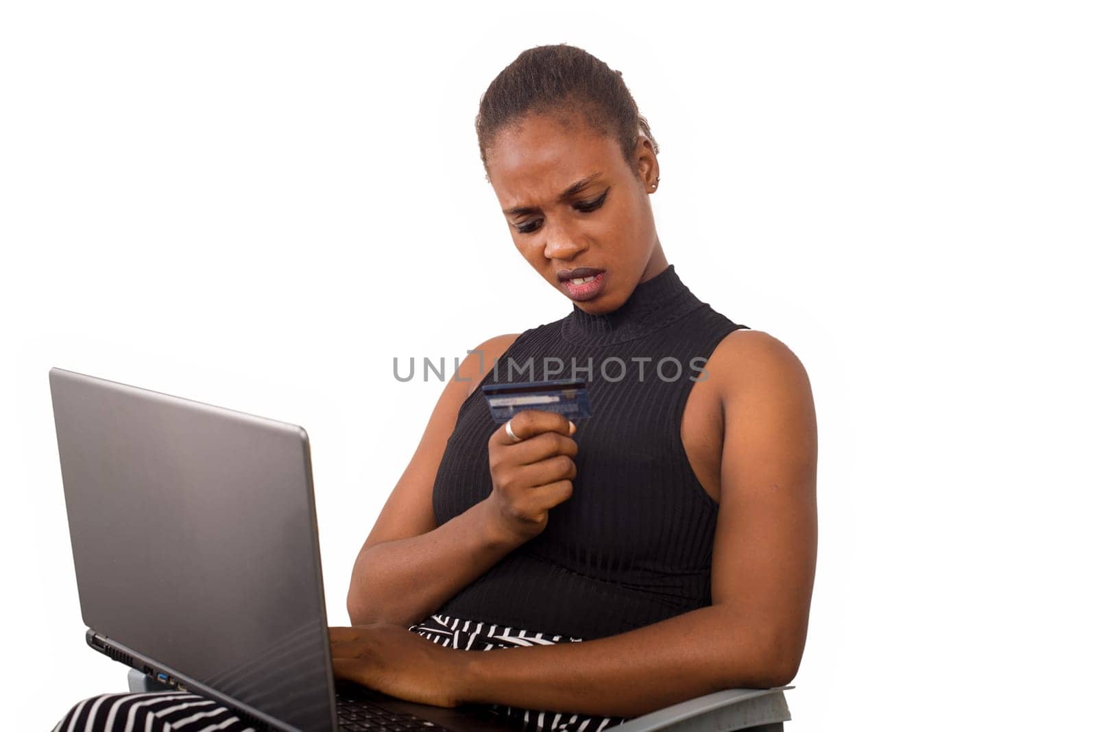 shocked businesswoman is looking at her credit card about to make online shopping with credit card using laptop in the office,