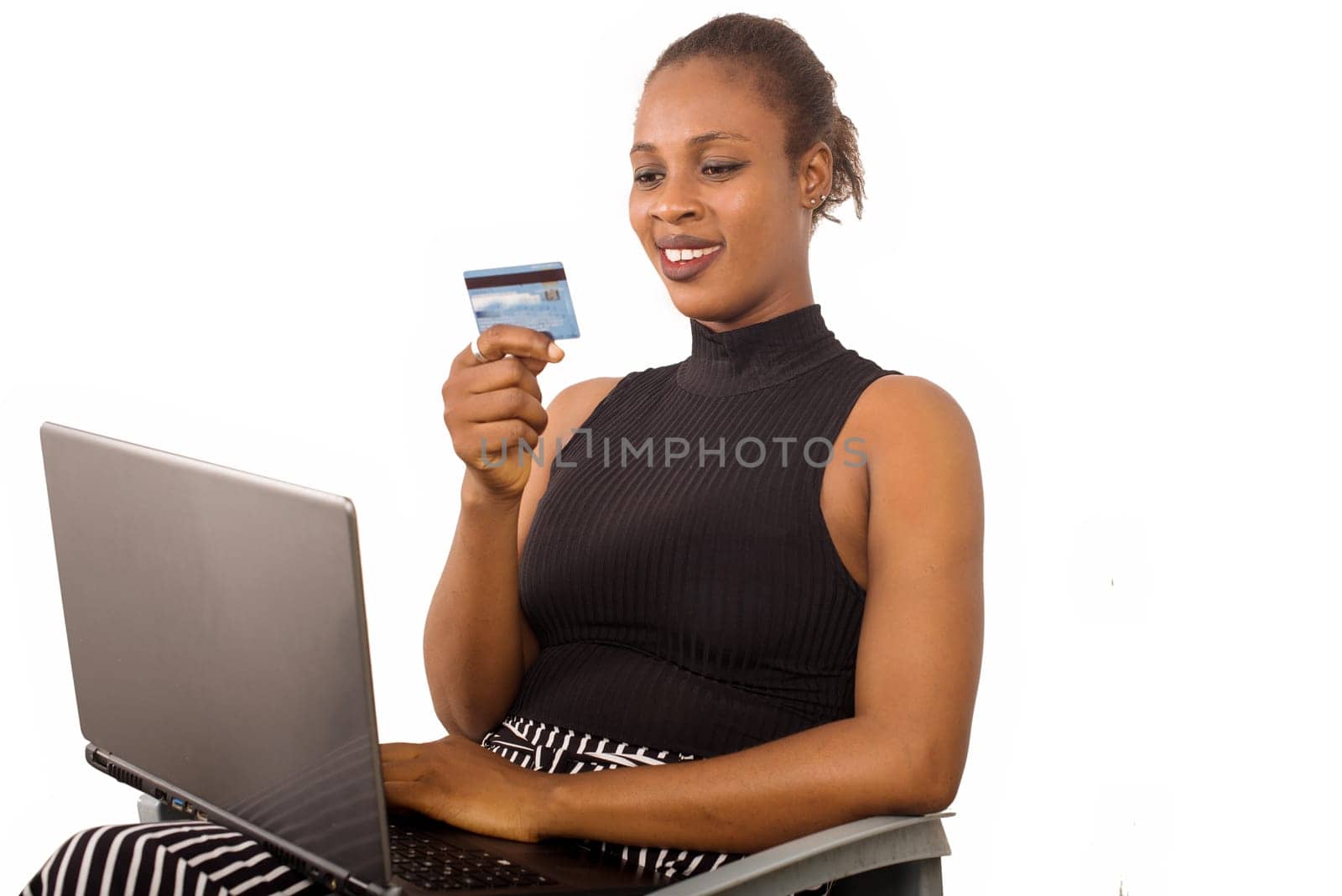 Cheerful pretty businesswoman shopping online with credit card using laptop in office