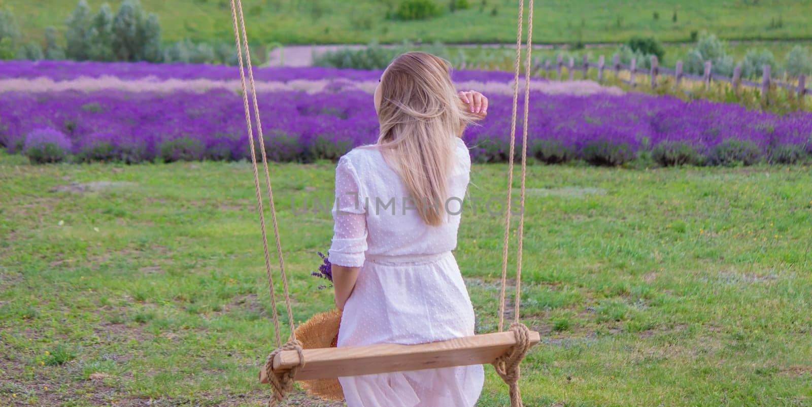 girl on a swing in a field of lavender. Selective focus. Nature