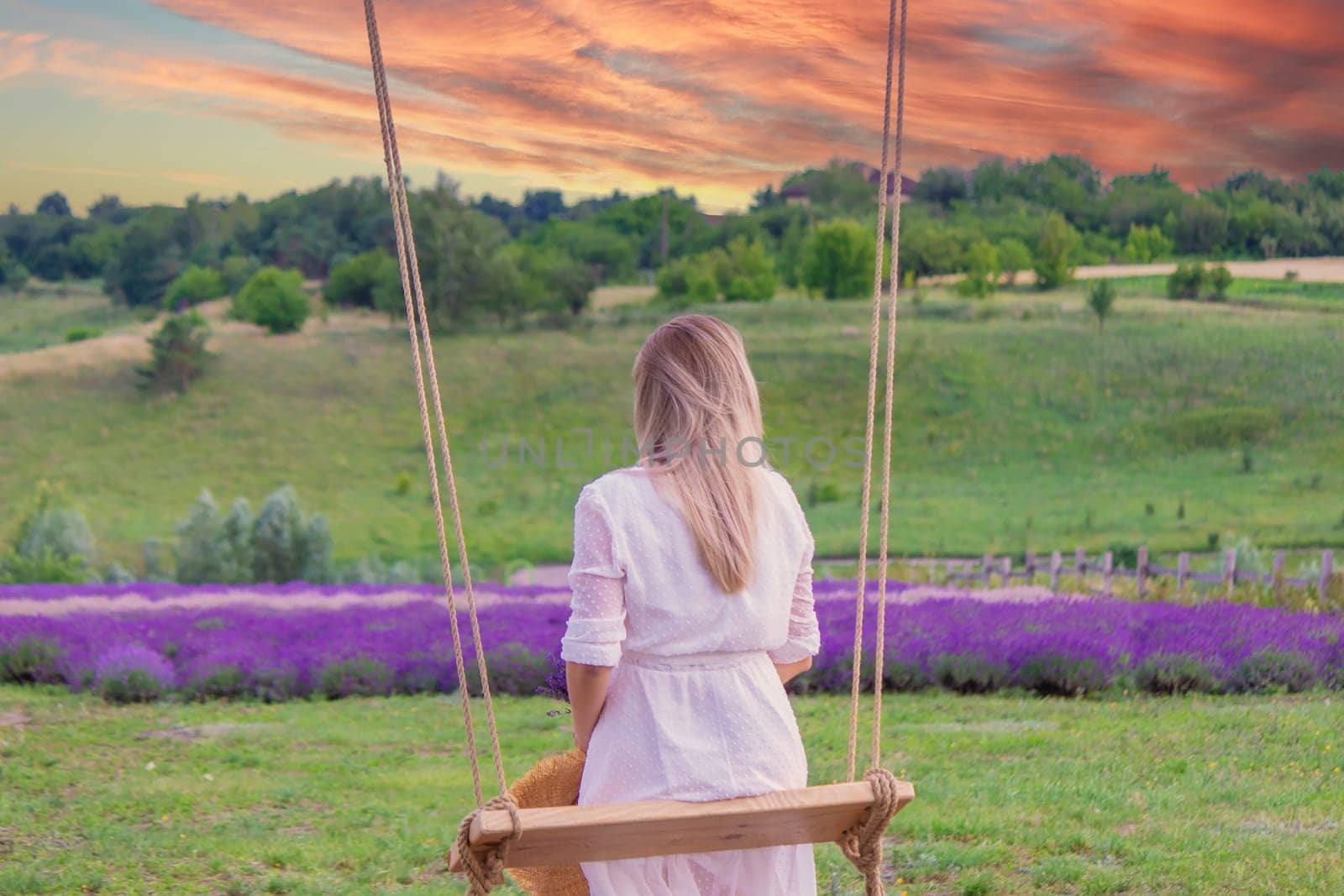 girl on a swing in a field of lavender. Selective focus. Nature