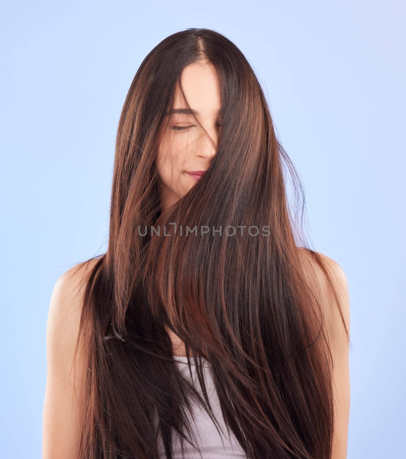 Luxury, texture and woman with hair care, cosmetics and wellness against a blue studio background. Female person, aesthetic and model with volume, wavy and scalp treatment with self care and beauty.