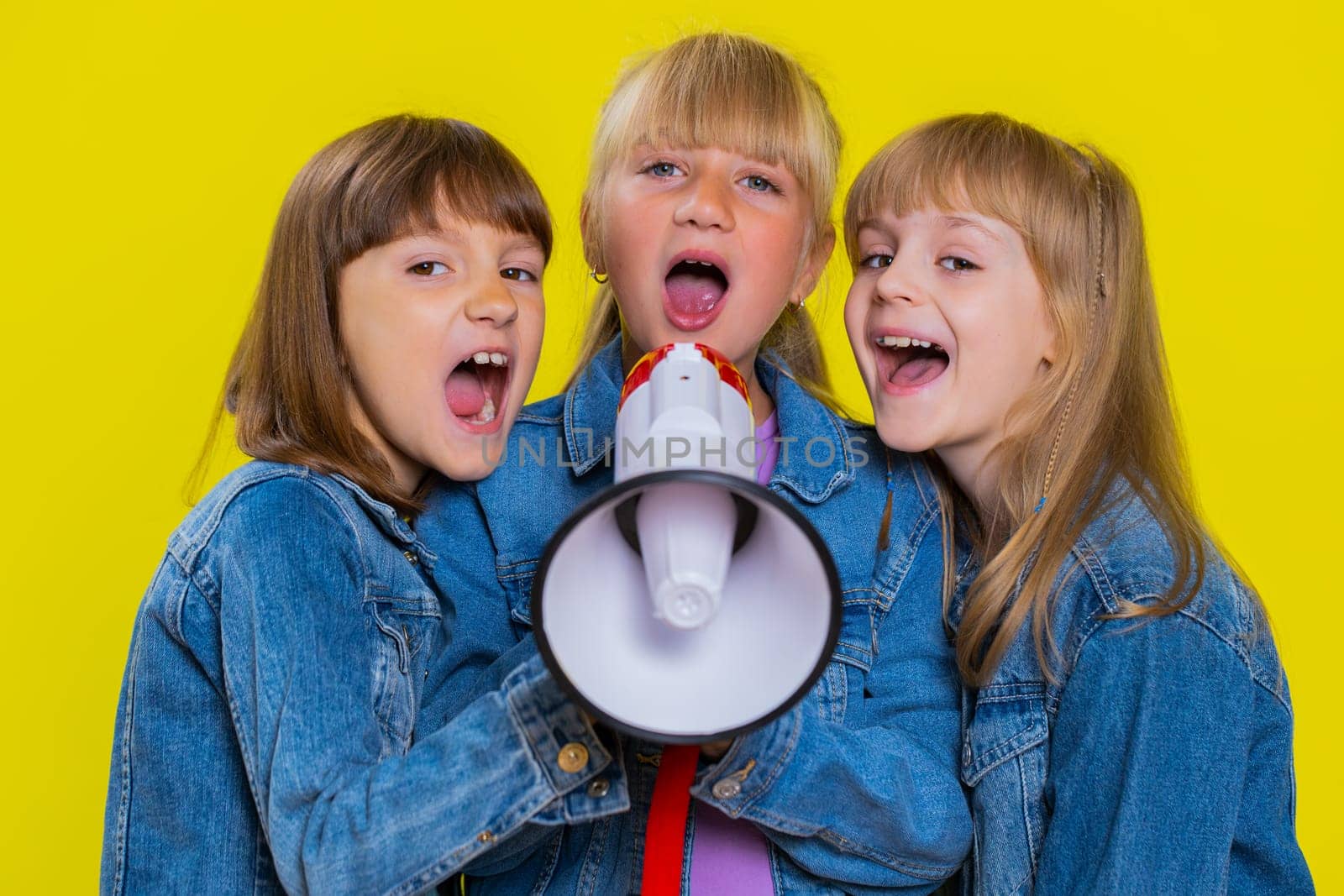 Three girls friends scream shout in megaphone proclaiming news, loudly announcing advertisement by efuror