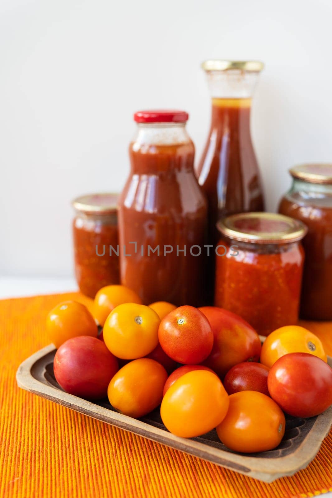 The process of preserving pickled tomatoes and peppers in glass jars on the table. Adjika, spicy-sweet vegetarian sauce for dishes