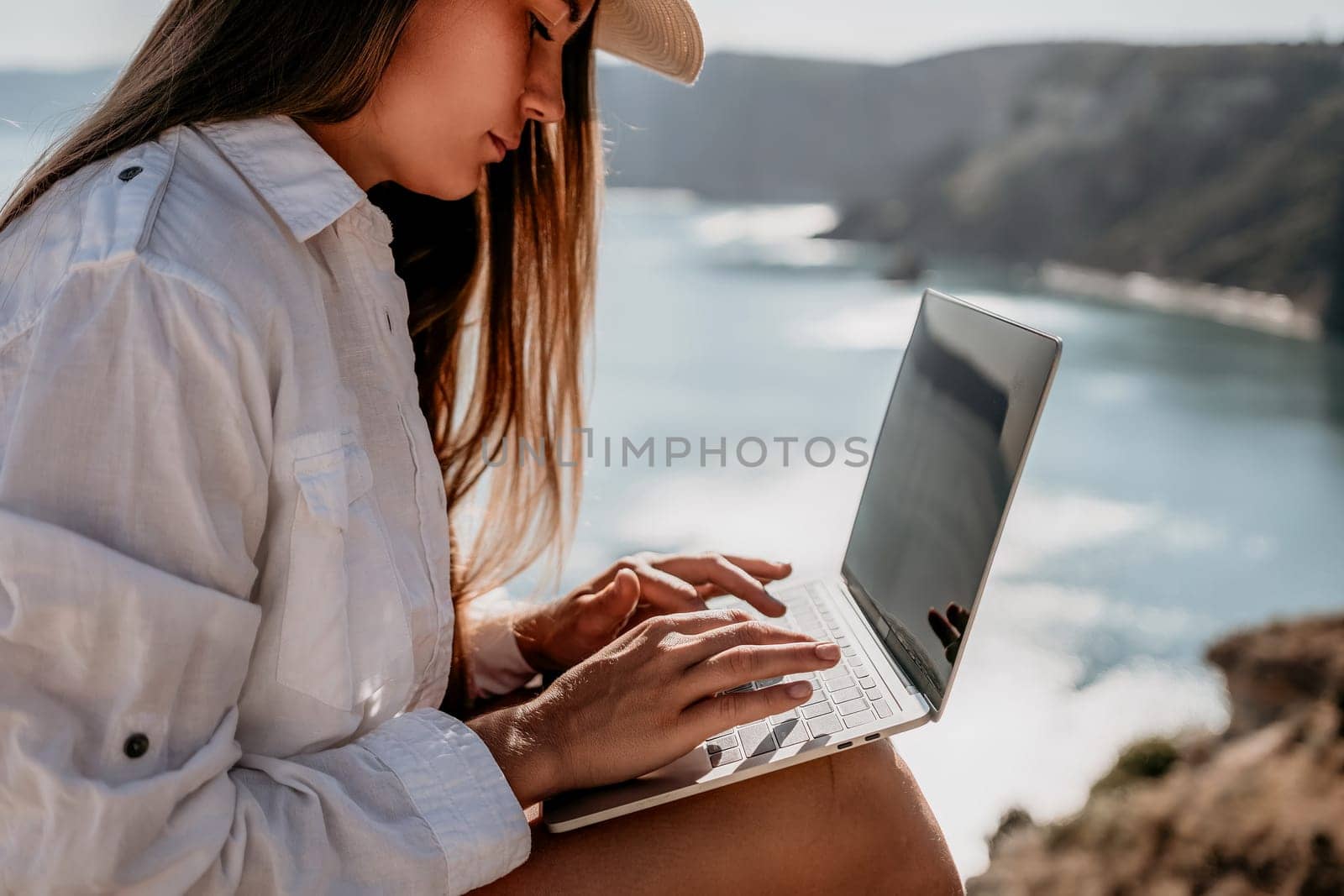 Happy girl doing yoga with laptop working at the beach. beautiful and calm business woman sitting with a laptop in a summer cafe in the lotus position meditating and relaxing. freelance girl remote work beach paradise