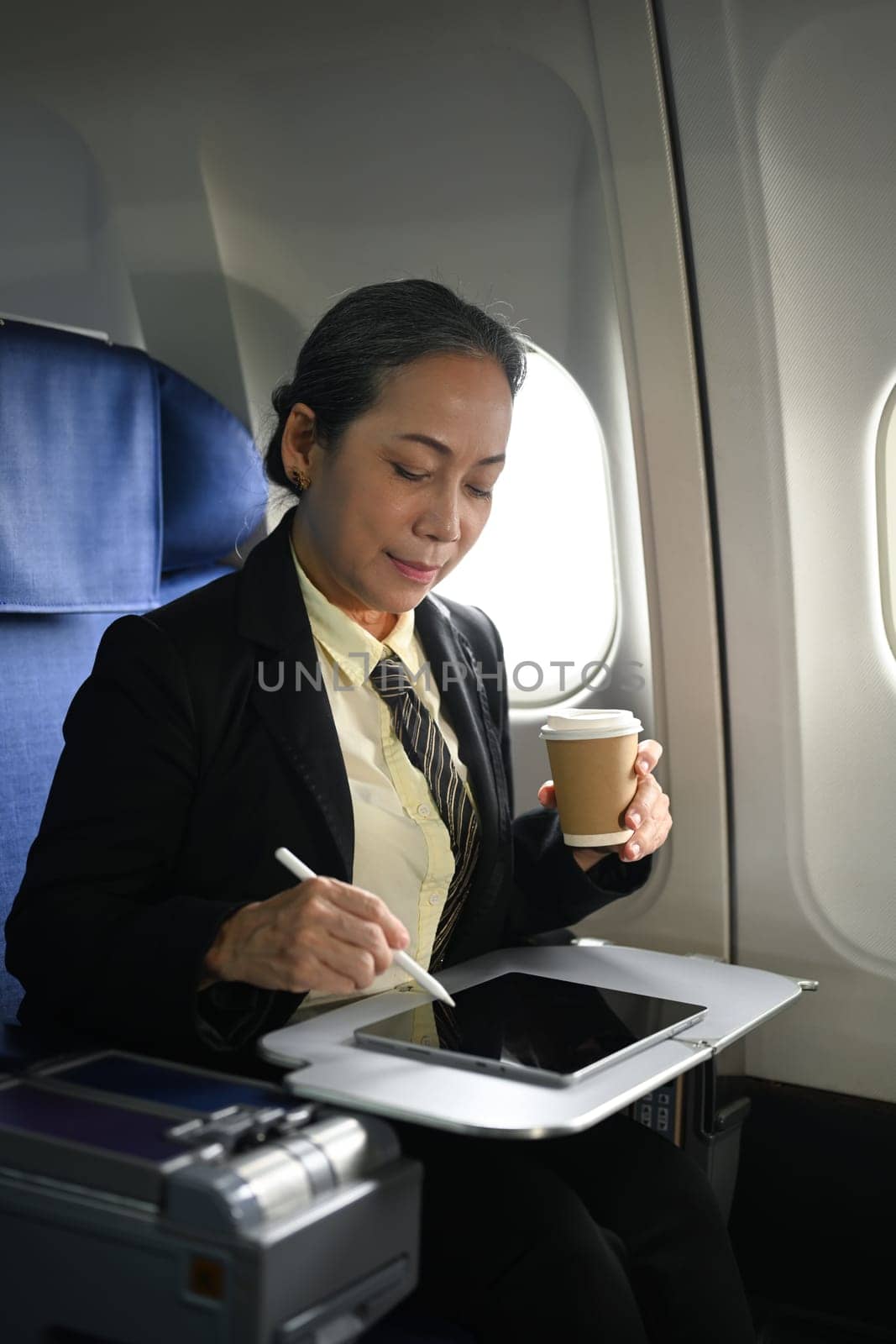 Image of senior businessman passenger sitting comfortable seat working with laptop on airplane cabin.