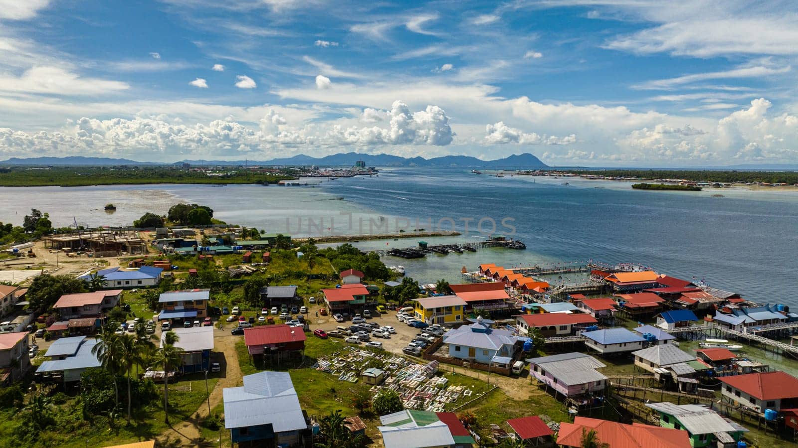 Aerial drone of traditional houses of fishermen and farmers on the water. Houses of the poor in Borneo. Semporna, Sabah, Malaysia.