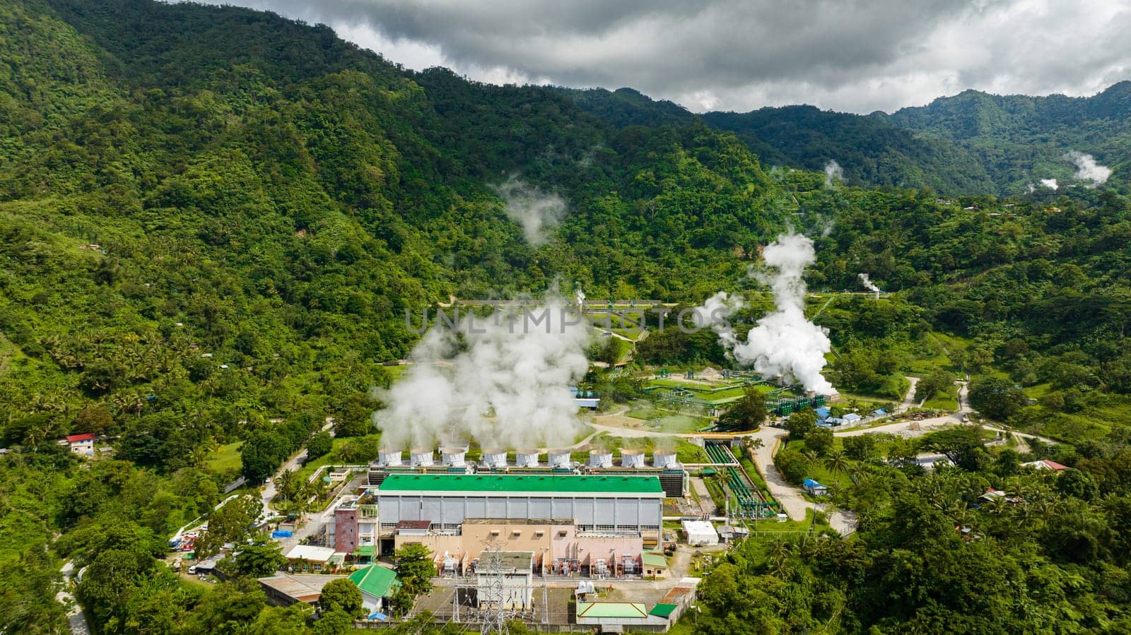 Aerial view of geotermal power plant in the mountains. Geothermal station with steam and pipes. Negros, Philippines.