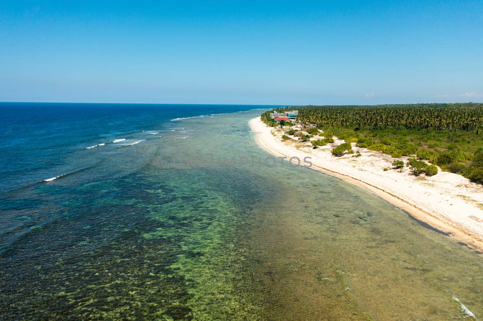 Wide sandy beach with ocean surf and waves. Philippines.