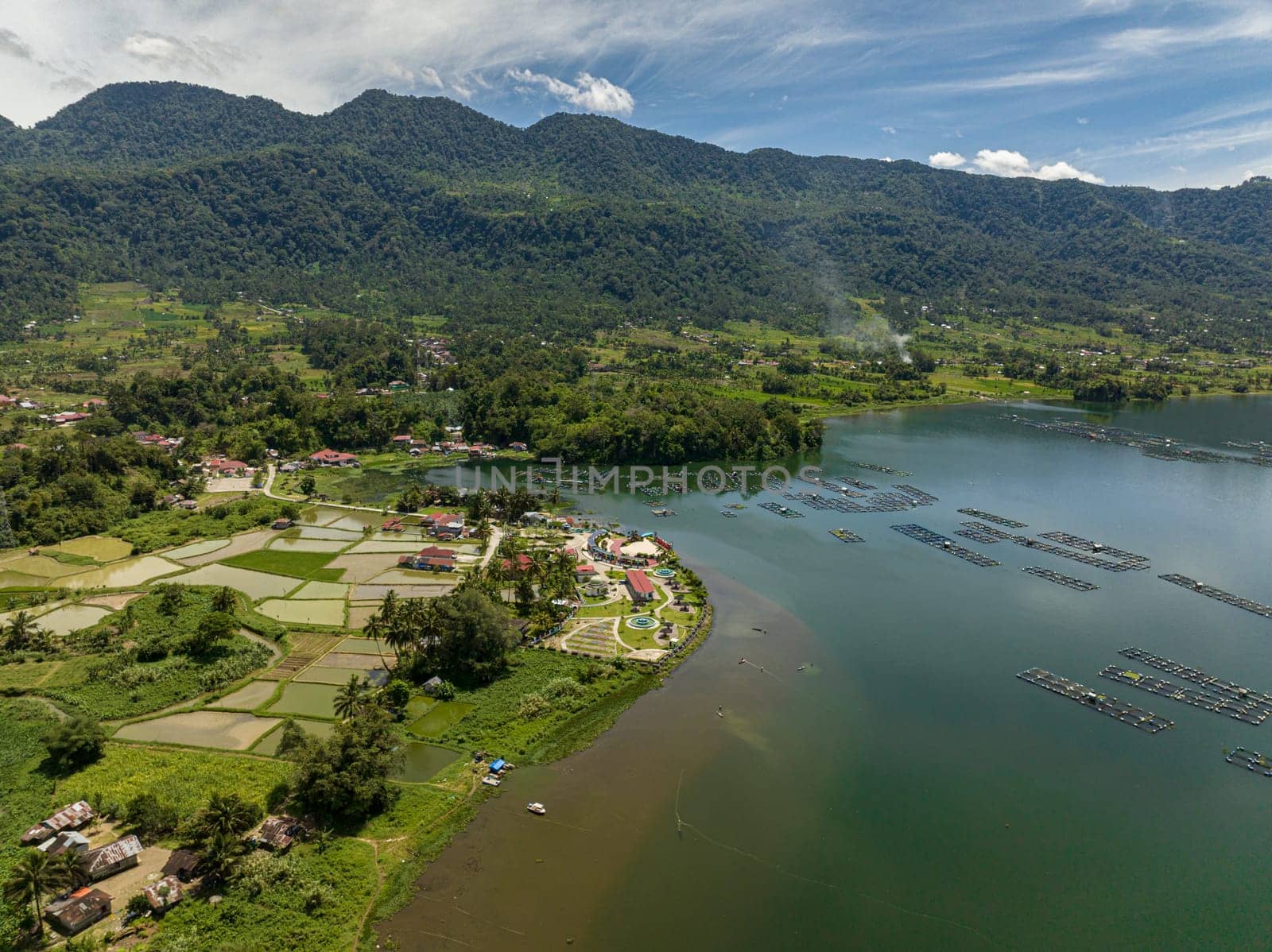Aerial view of farmland and rice fields on the Maninjau lake shore in the mountains. Sumatra, Indonesia.