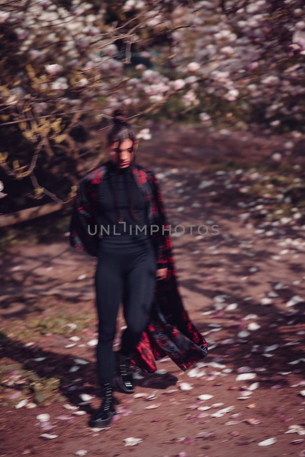 Beautiful dramatic young woman wearing black kimono with cherry blossoms, sakura view. High quality photo