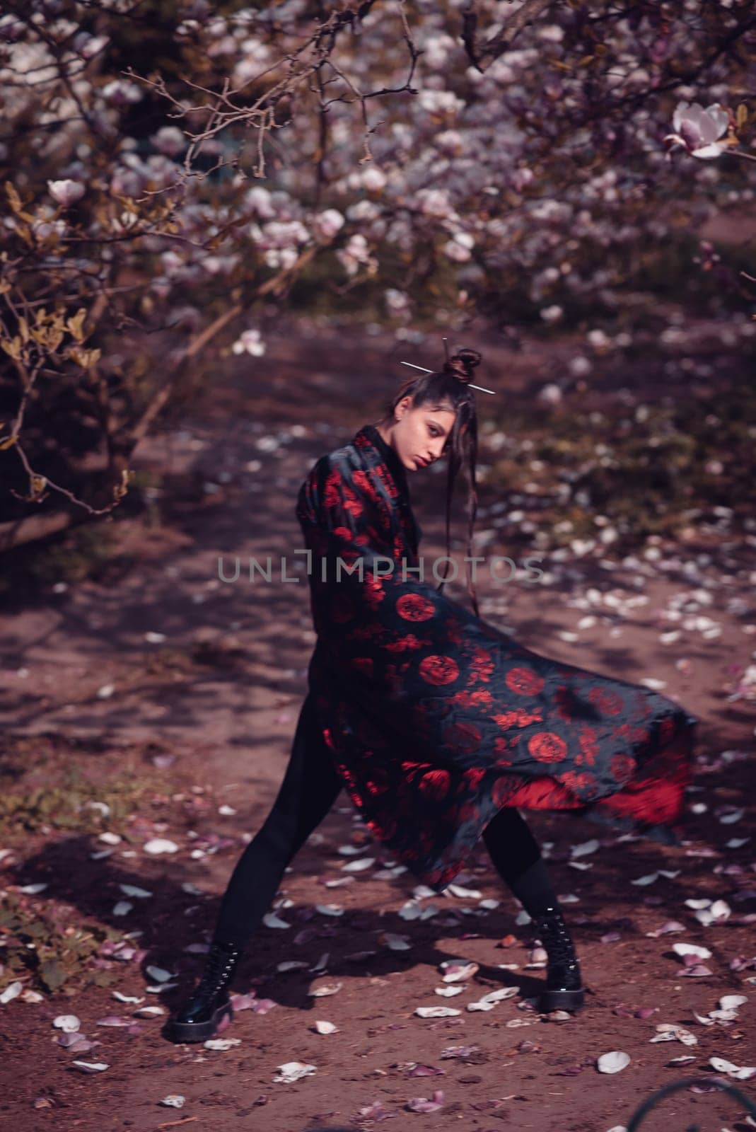 Beautiful dramatic young woman wearing kimono with cherry blossoms, sakura view. High quality photo