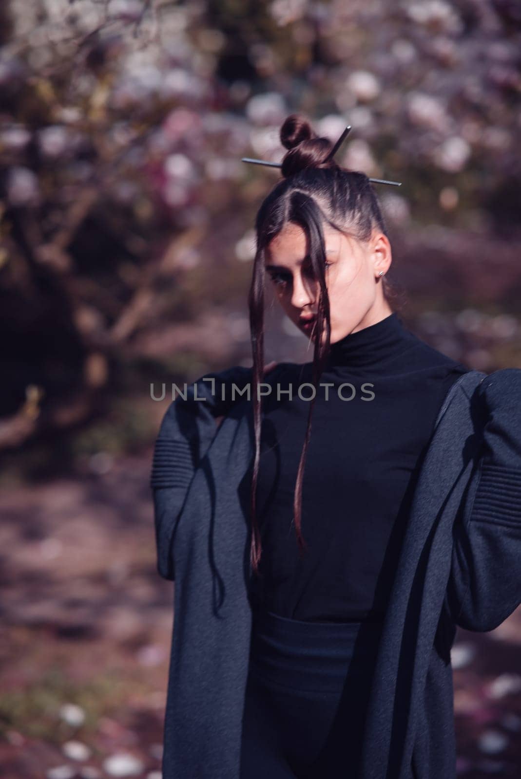 Beautiful dramatic young woman wearing kimono with cherry blossoms, sakura view. High quality photo