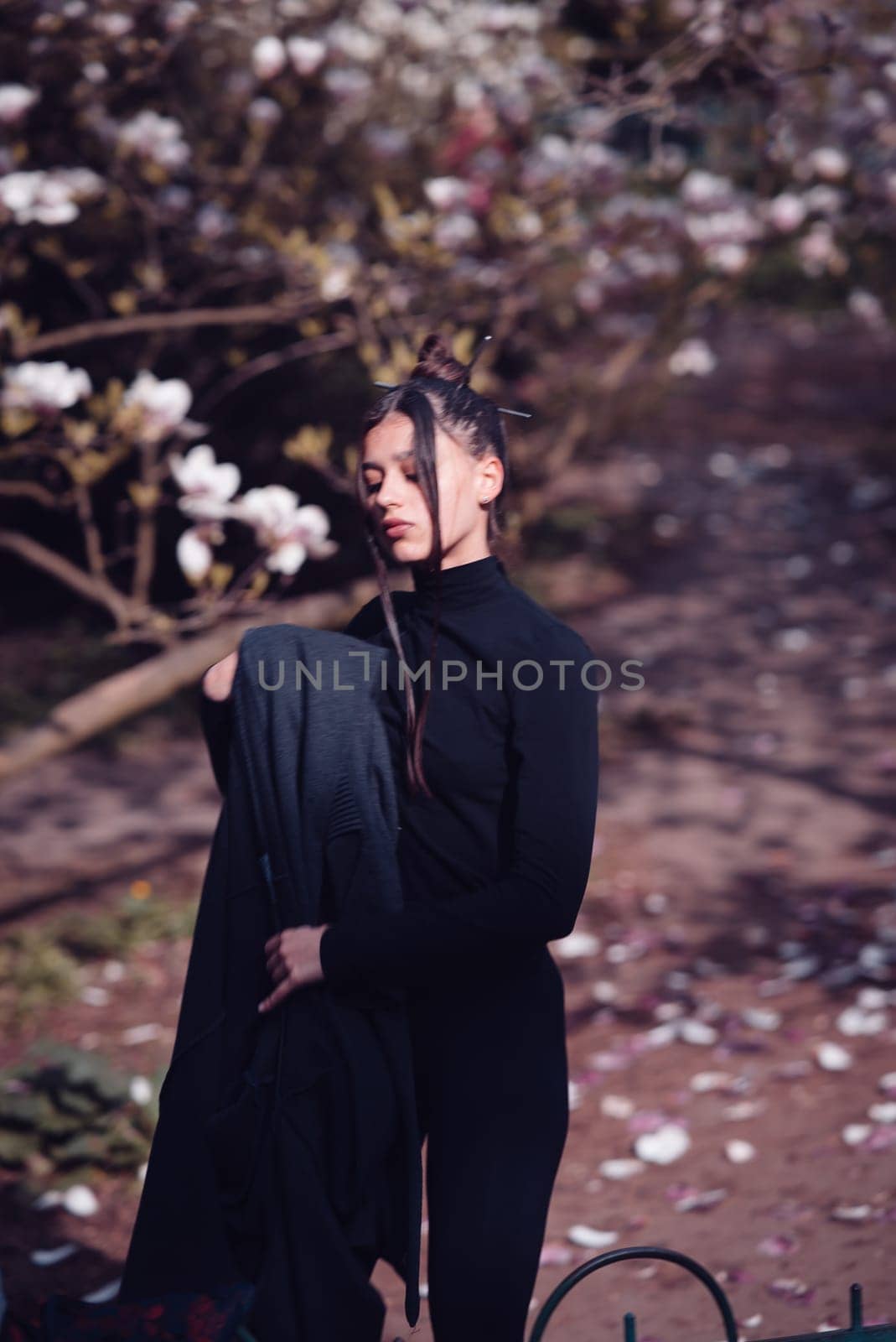 Beautiful dramatic young woman wearing kimono with cherry blossoms, sakura view. High quality photo