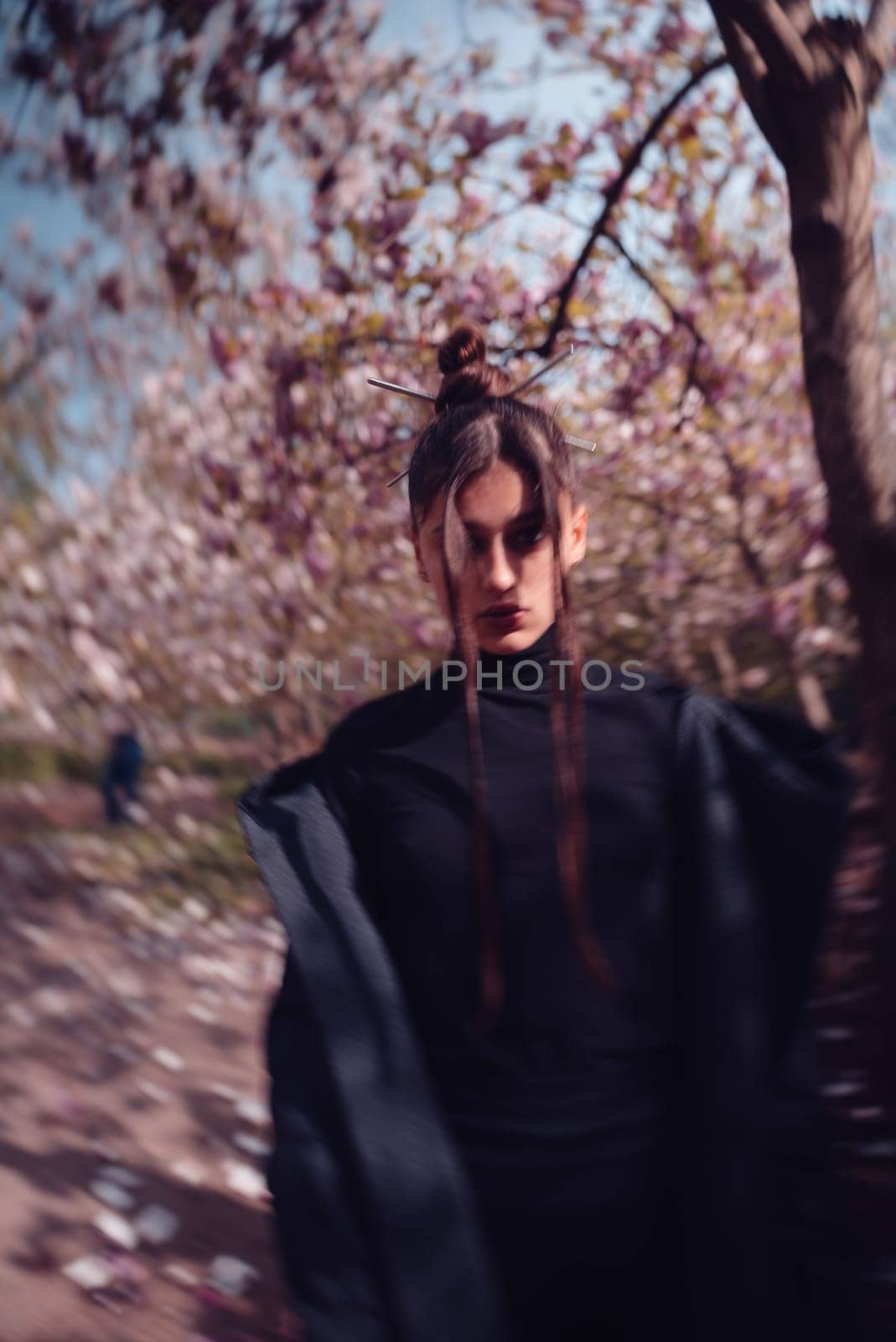 Beautiful dramatic young woman wearing kimono with cherry blossoms, sakura view. High quality photo