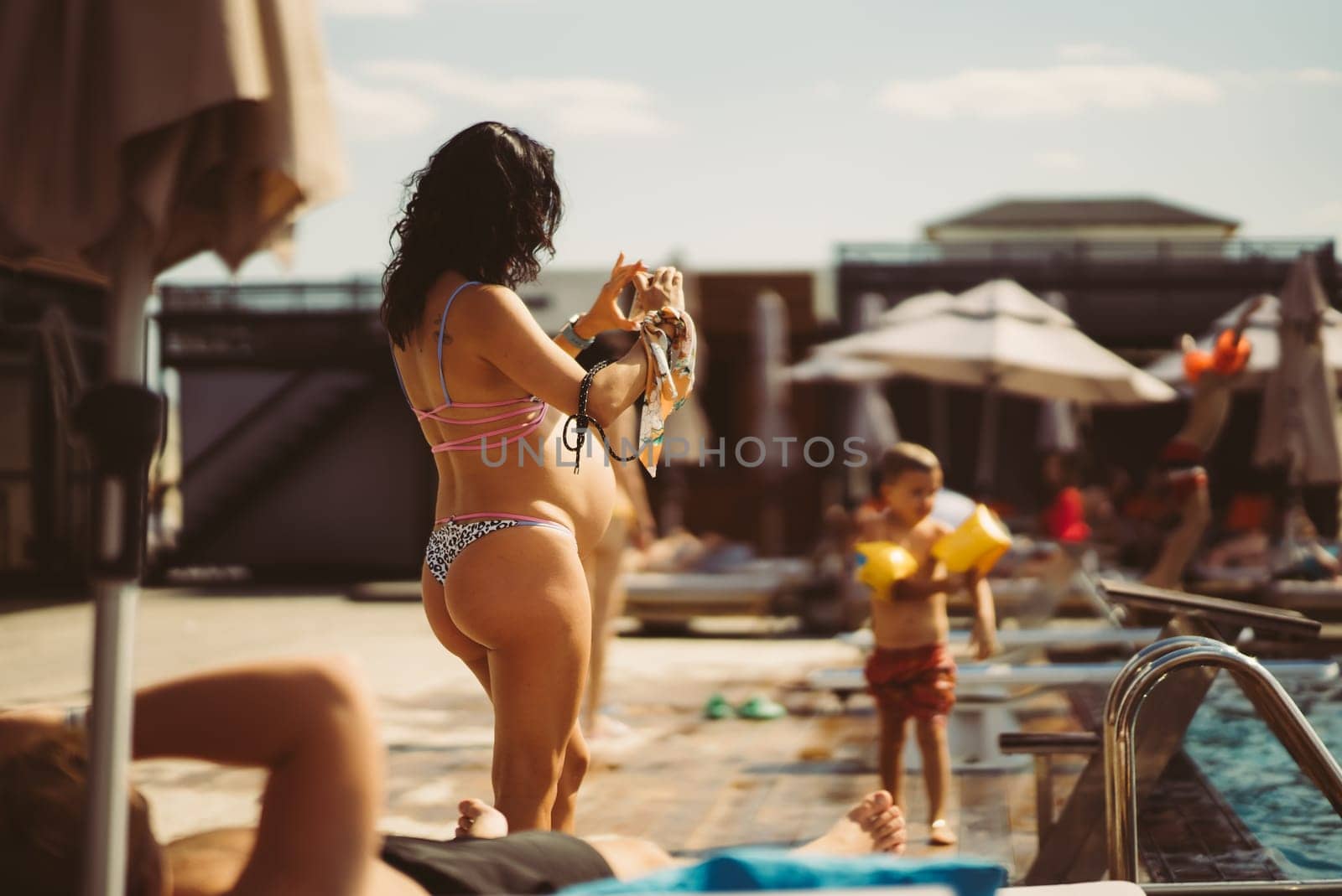 back view of pregnant woman in bikini on the beach. High quality photo