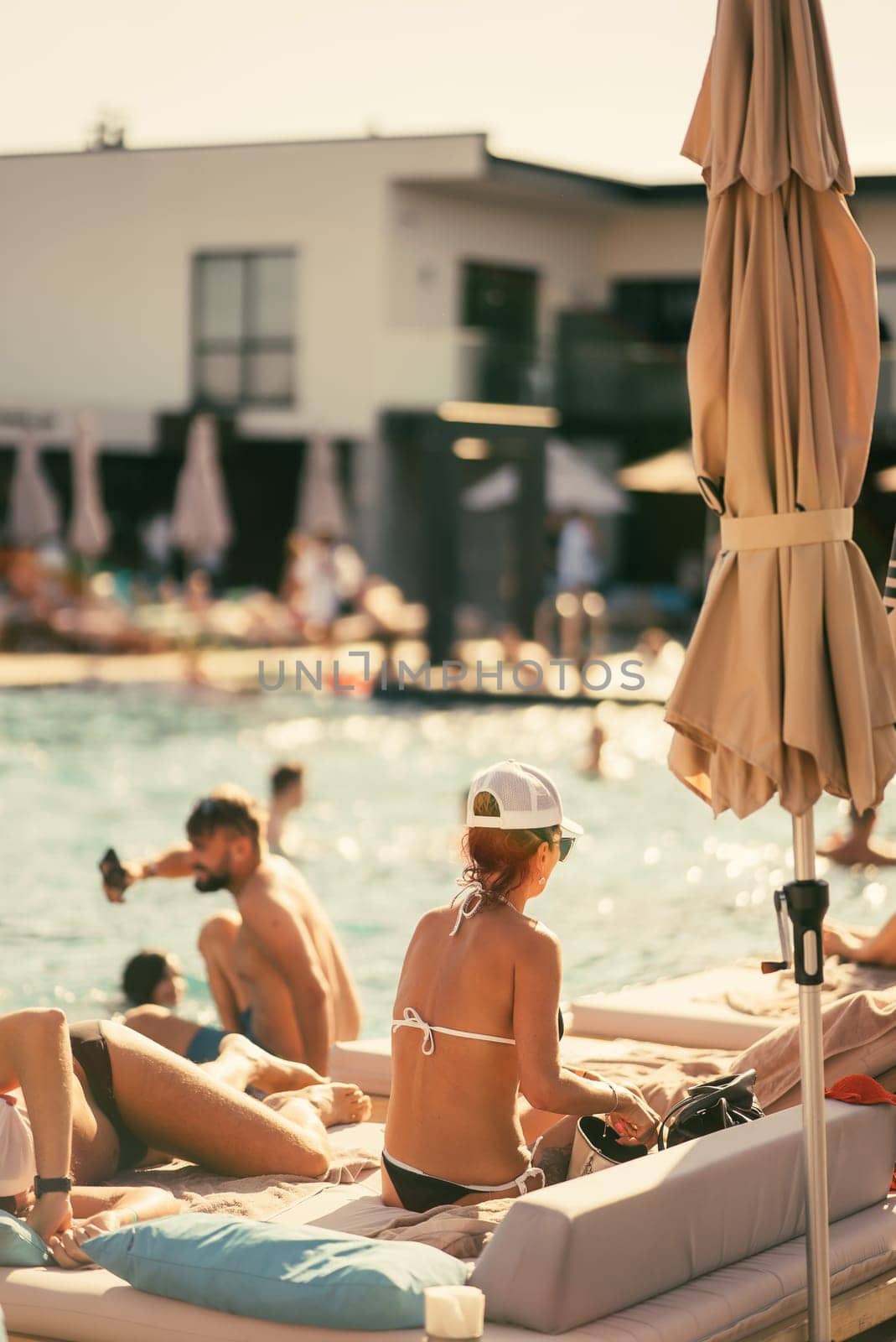 back view of people sunbathing on the beach. High quality photo