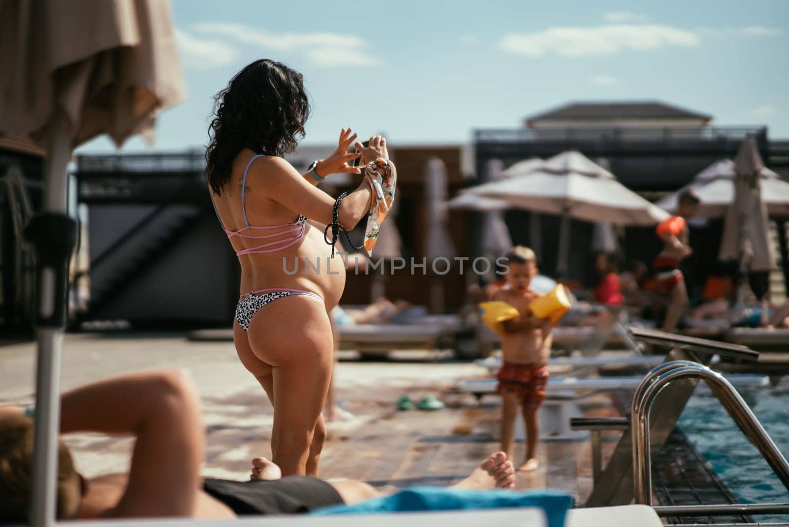 back view of pregnant woman in bikini on the beach. High quality photo