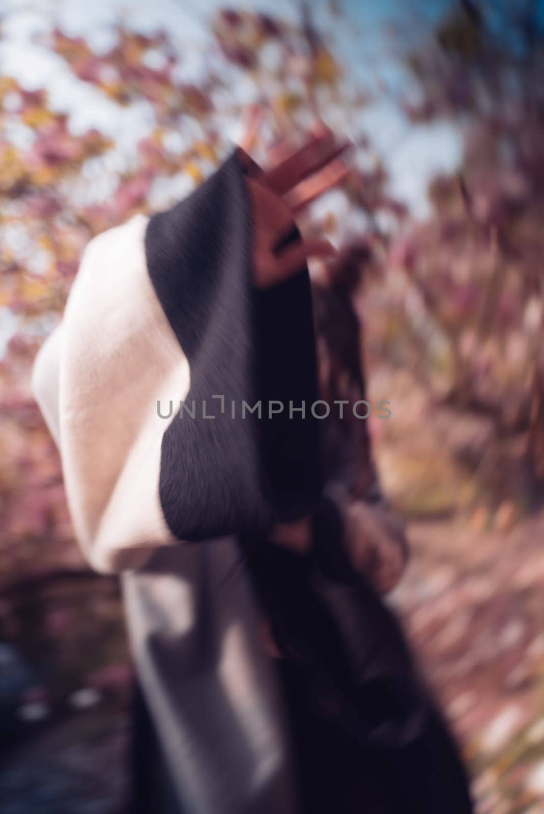 Beautiful dramatic young woman hiding her face wearing kimono with cherry blossoms, sakura view. High quality photo