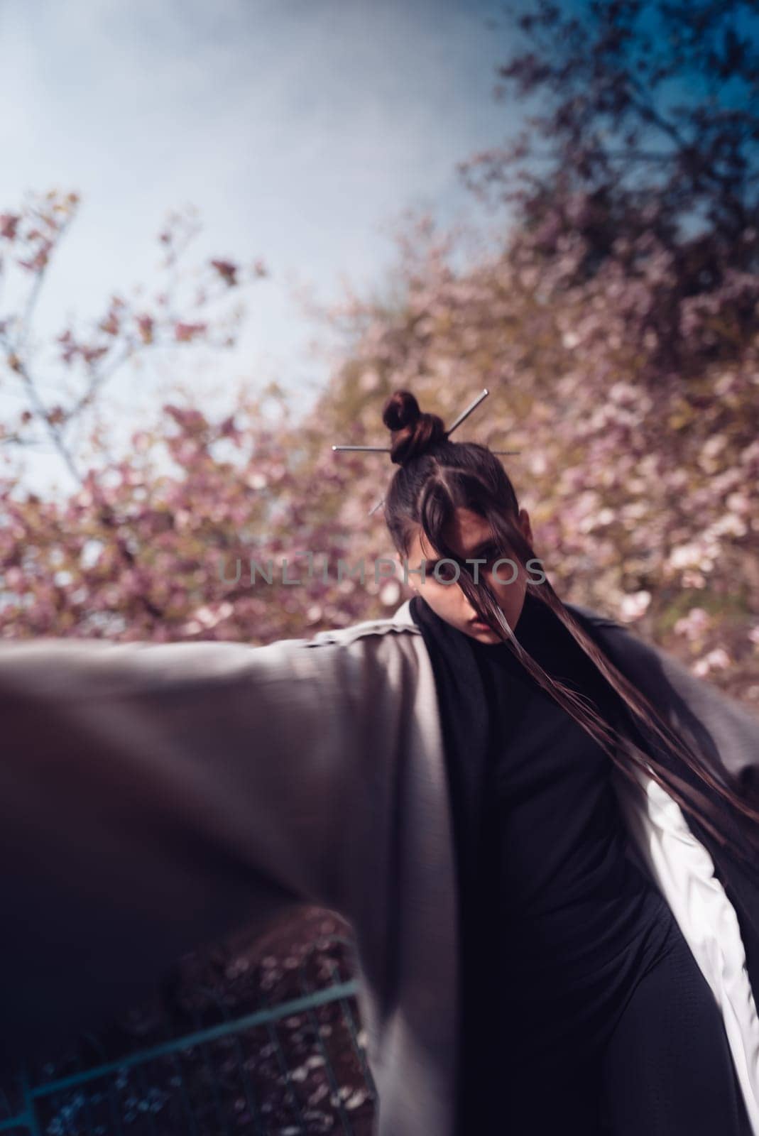 Beautiful dramatic young woman wearing kimono with cherry blossoms, sakura view. High quality photo