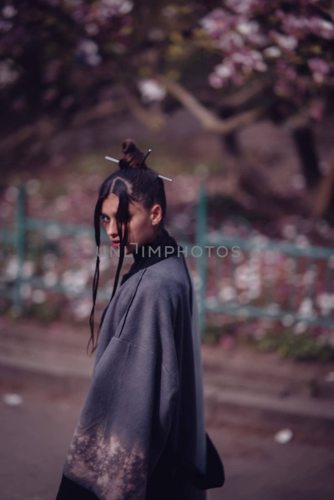 Beautiful dramatic young woman wearing kimono with cherry blossoms, sakura view. High quality photo